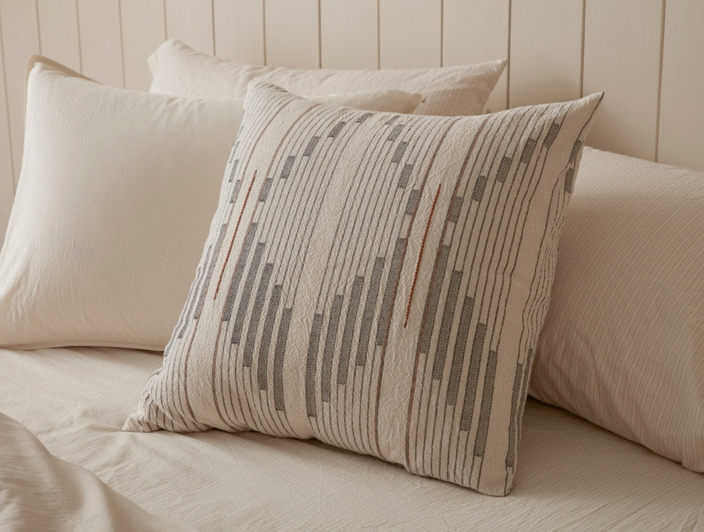 Coyuchi Morelia pillow cover, close-up of gray stripe and dash embroidery on ivory linen.