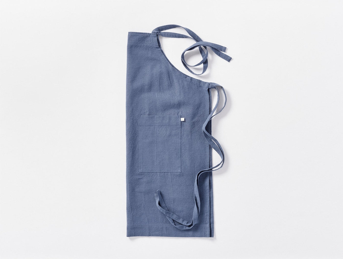 Coyuchi Sonoma Textured apron in slate blue linen, flat lay showing front pocket and ties.