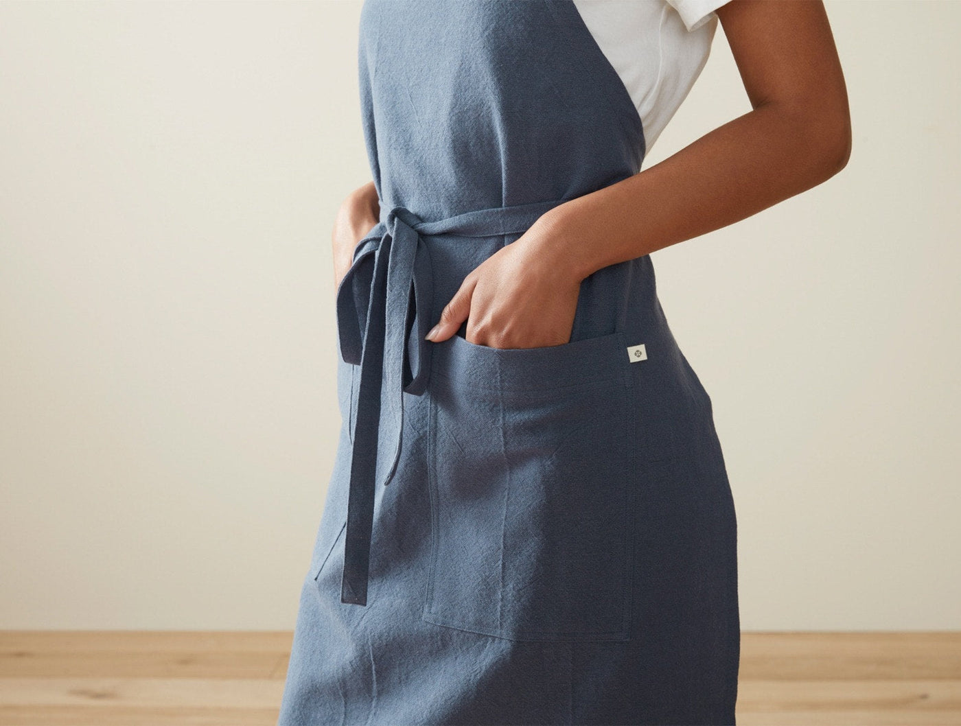 Close-up of Coyuchi Sonoma apron pocket and tie detail in slate blue linen.