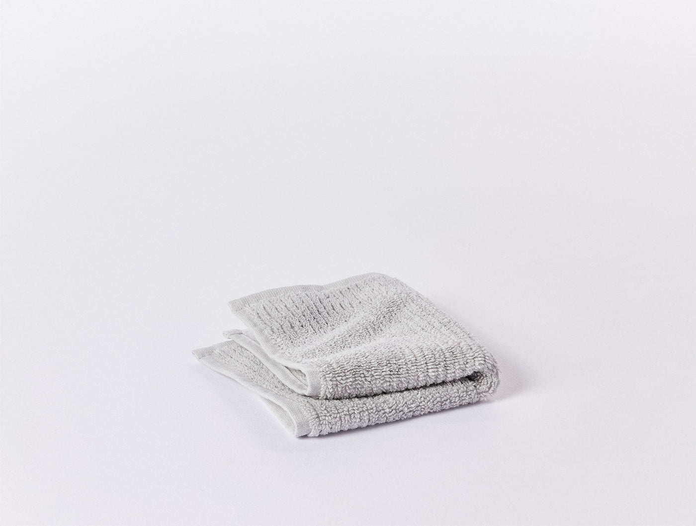 Folded grey ribbed washcloth showing textured weave detail, from Coyuchi Temescal set.