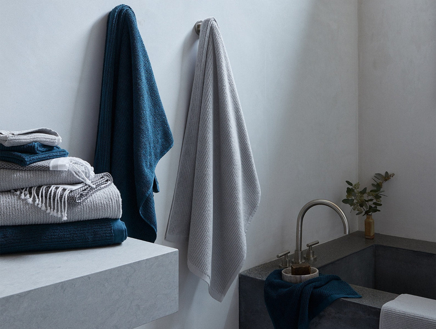 Coyuchi Temescal Ribbed towels styled in bathroom, slate and navy stacked and hung.