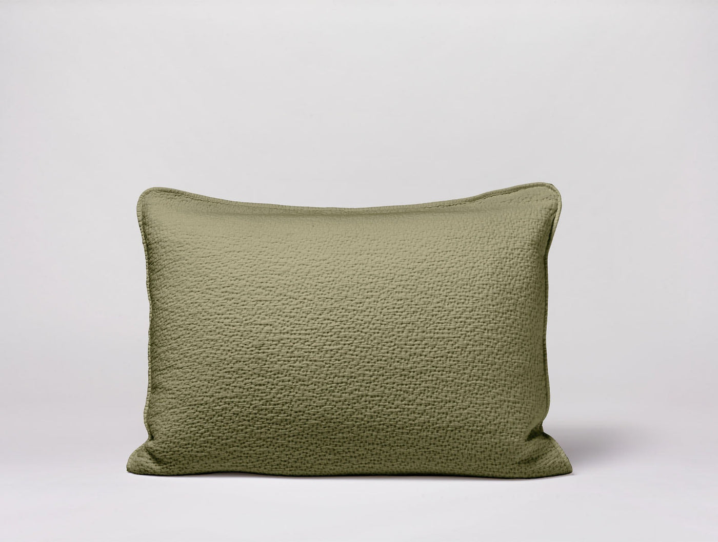 Olive green matelasse pillow sham with subtle textured surface and self-piped edge.