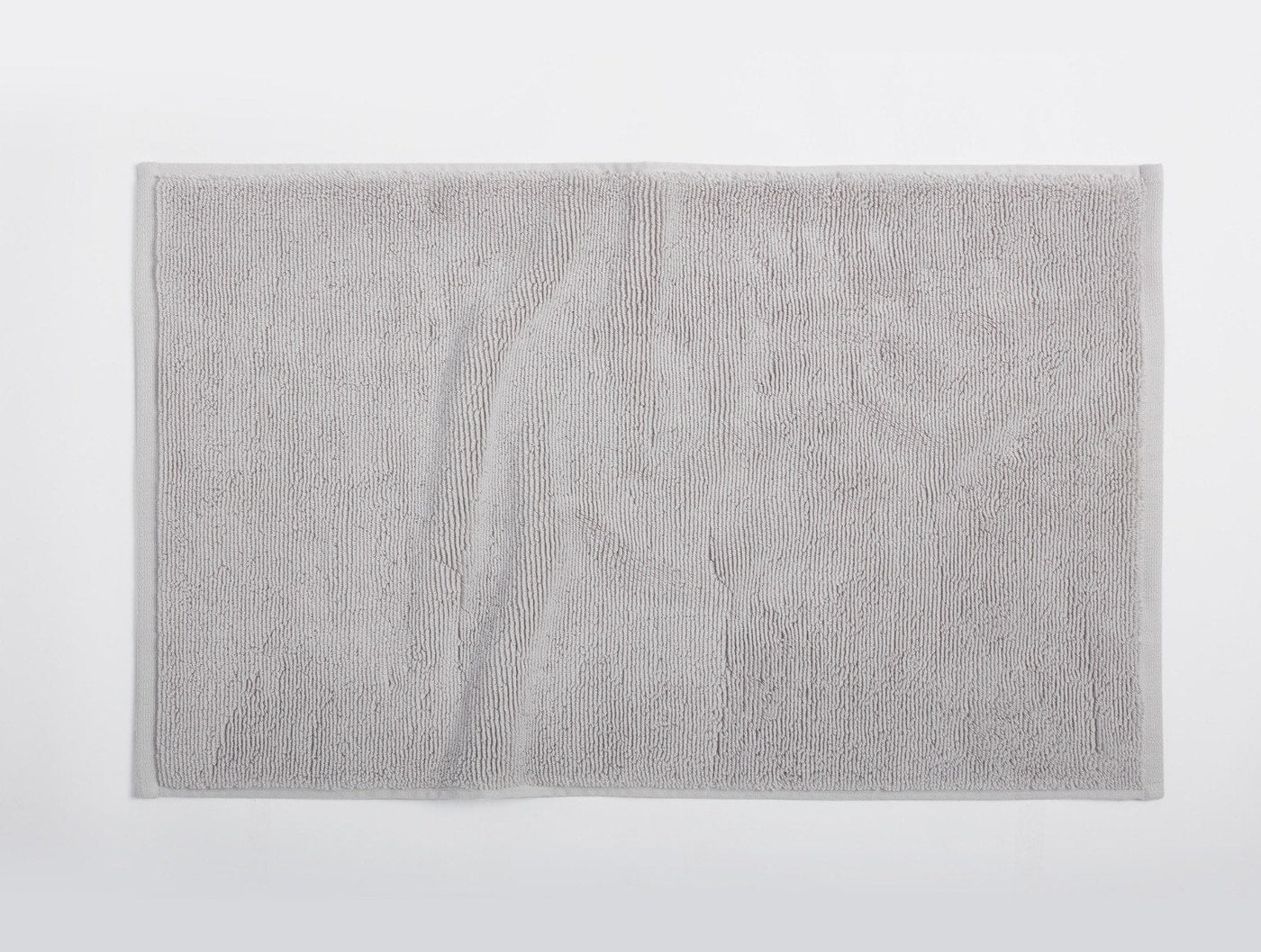 Coyuchi Cloud Loom bath rug in silver grey, flat lay showing full terry texture.