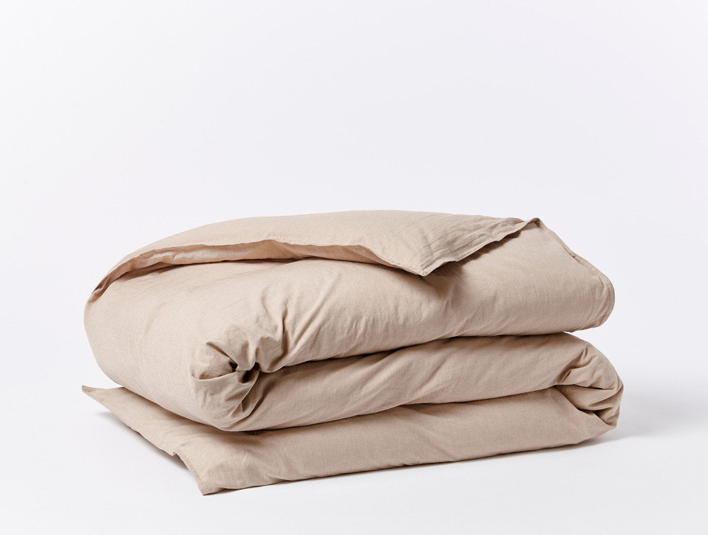 Coyuchi Crinkled Percale duvet cover folded, showing sand linen texture against white background.