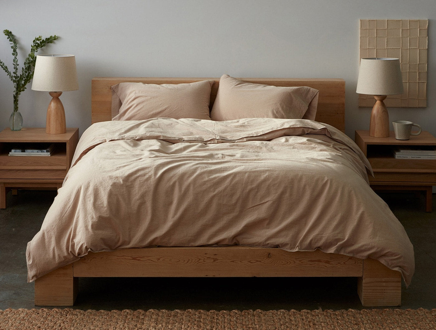 Coyuchi Crinkled Percale duvet cover in warm taupe, styled on a low oak bed.