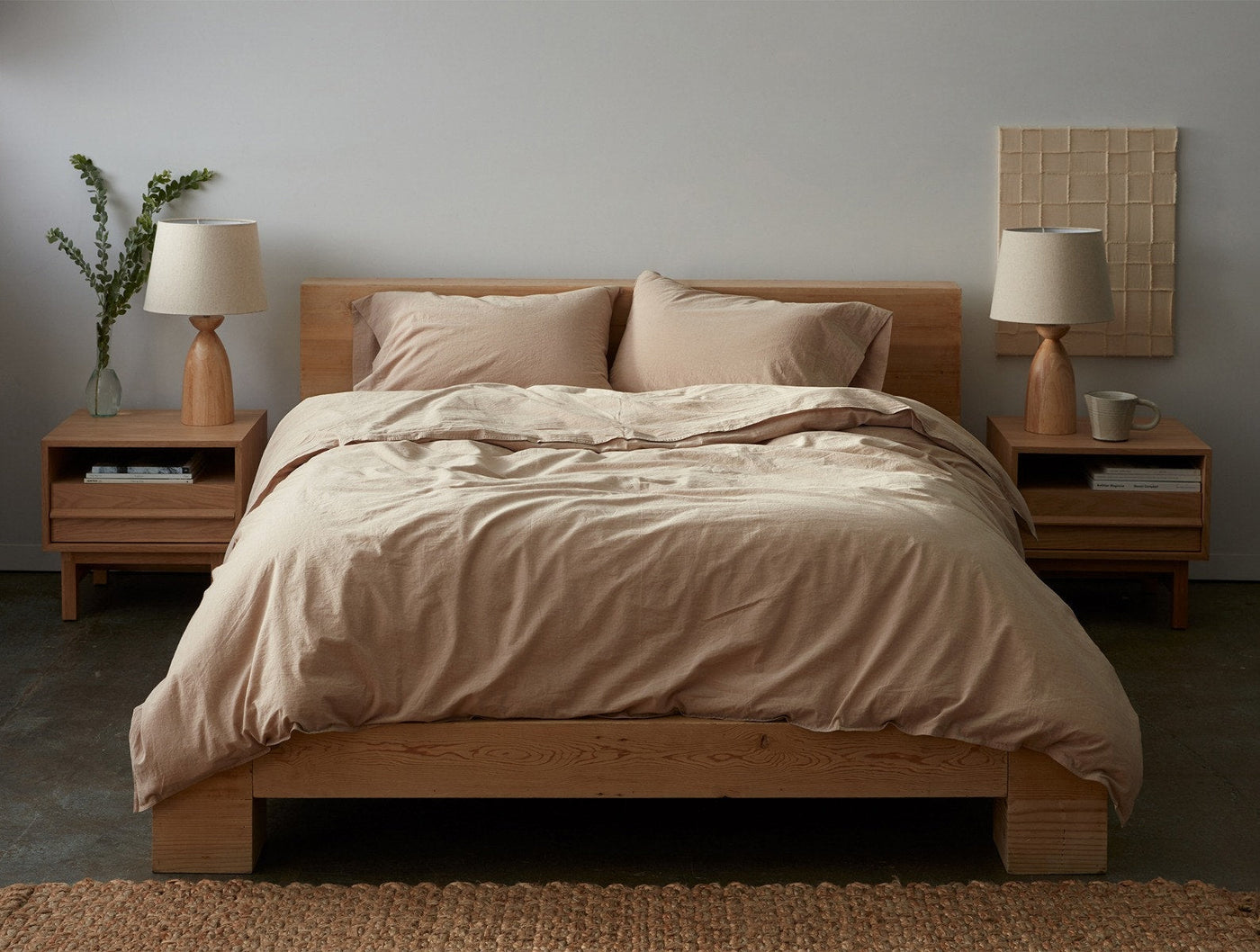Camel and oat Coyuchi Crinkled Percale sheets styled on low oak bed with neutral bedroom setting.