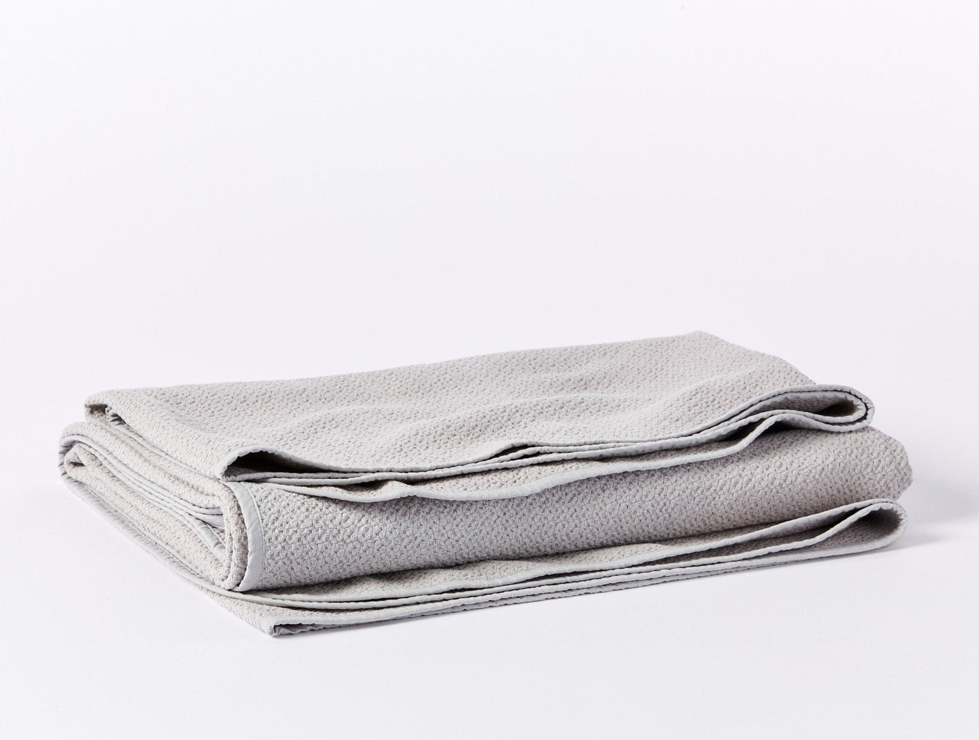 Coyuchi Honeycomb blanket folded in silver, showing textured weave and finished hem.