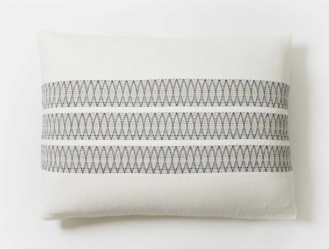 Close-up of Coyuchi Lost Coast sham showing zigzag embroidered charcoal stripe detail on ivory cotton.