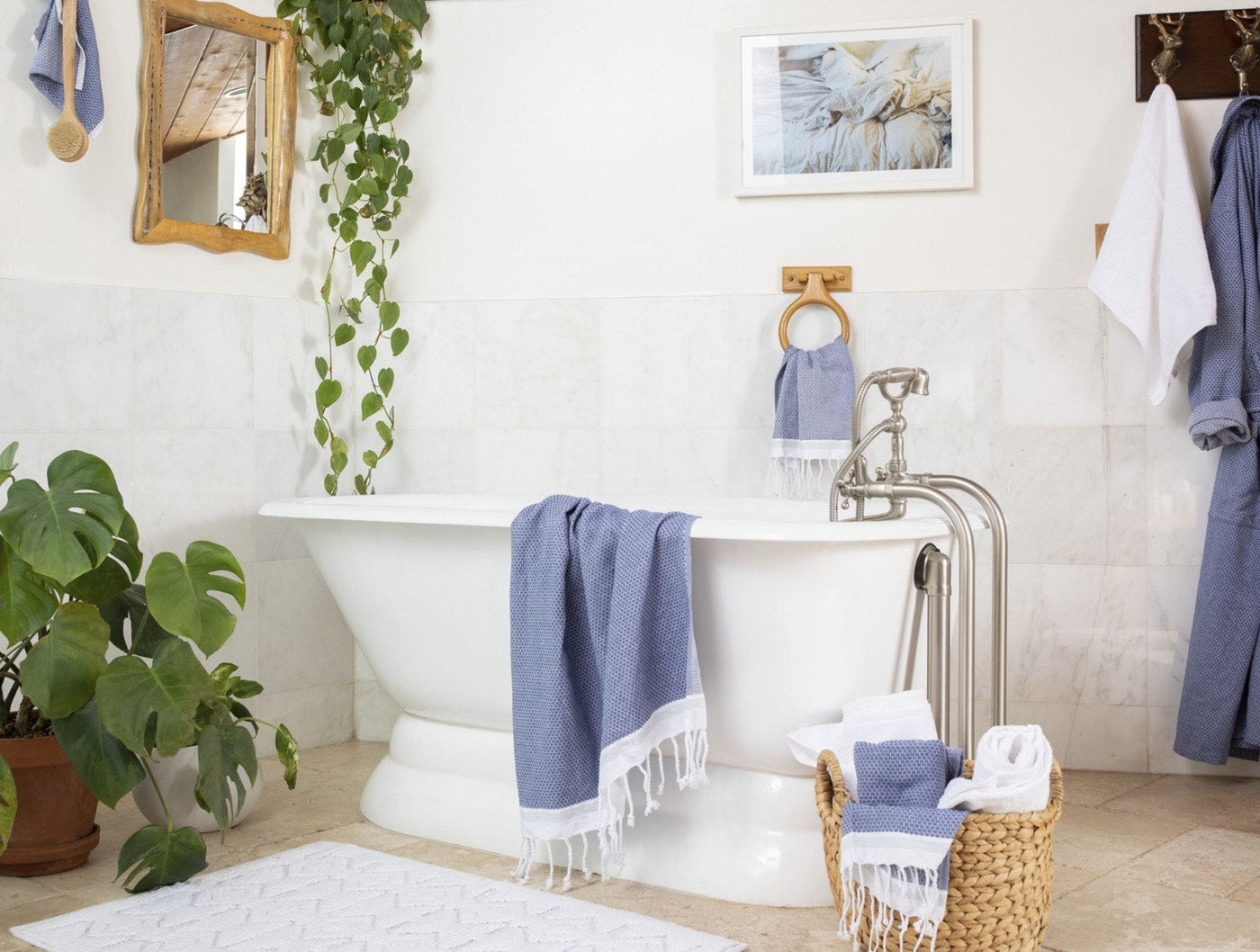Coyuchi Mediterranean guest towels in blue draped over a freestanding bathtub.