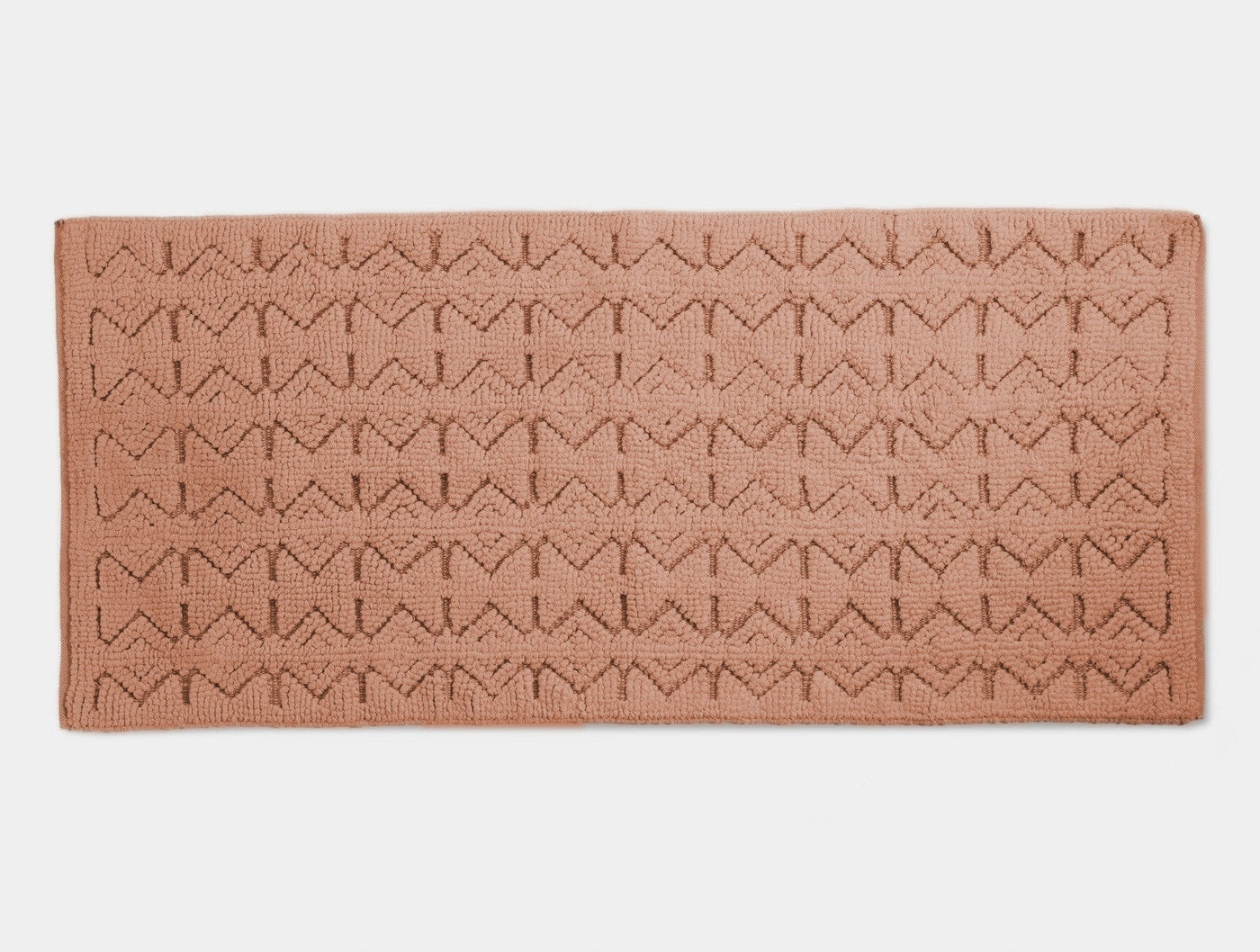 Close-up of Coyuchi Mosaic Canyon bath runner in terracotta with geometric woven pattern.