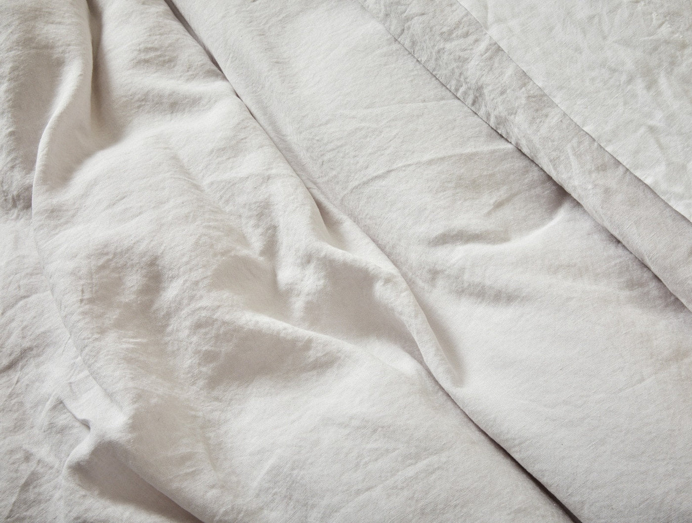 Close-up of Coyuchi Relaxed Linen sham in white, showing soft drape and natural wrinkle texture.