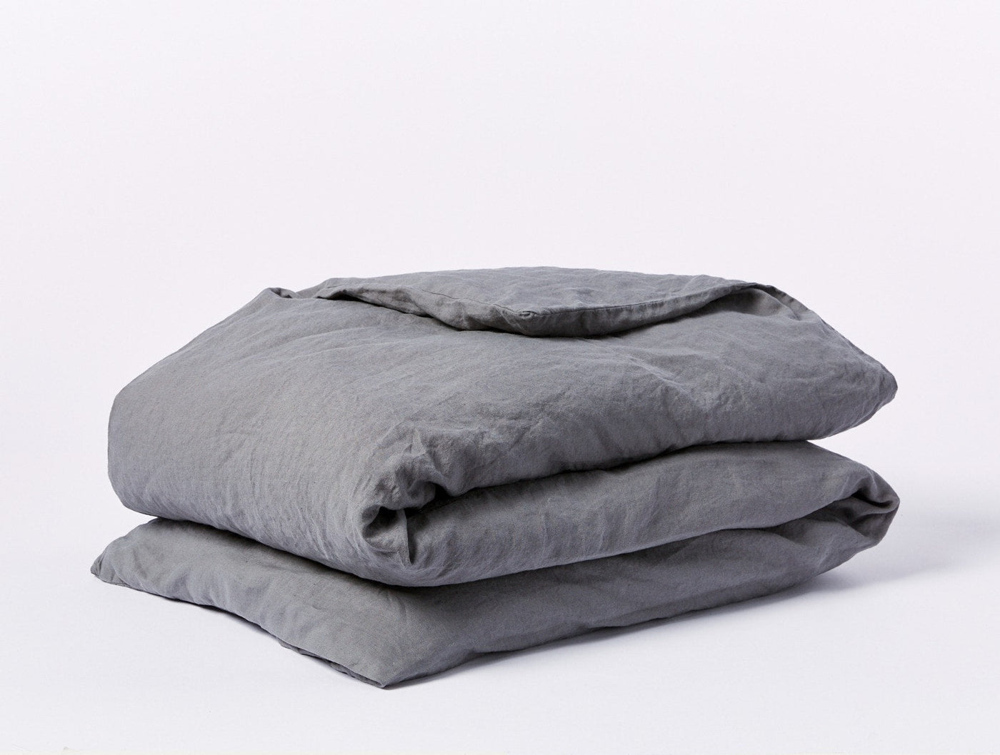 Folded Coyuchi Relaxed Linen duvet cover in slate grey, showing natural wrinkled texture.