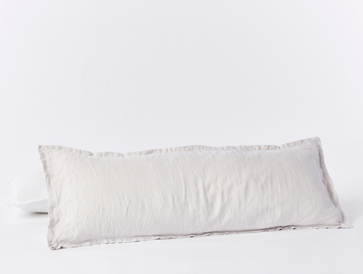 Coyuchi Relaxed Linen long lumbar pillow in white with ruffled trim detail.