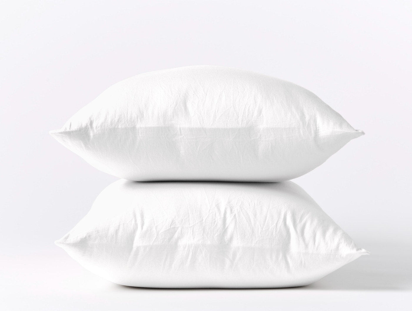 Coyuchi Cloud Soft Sateen pillowcase pair in white, two pillows stacked against white background.