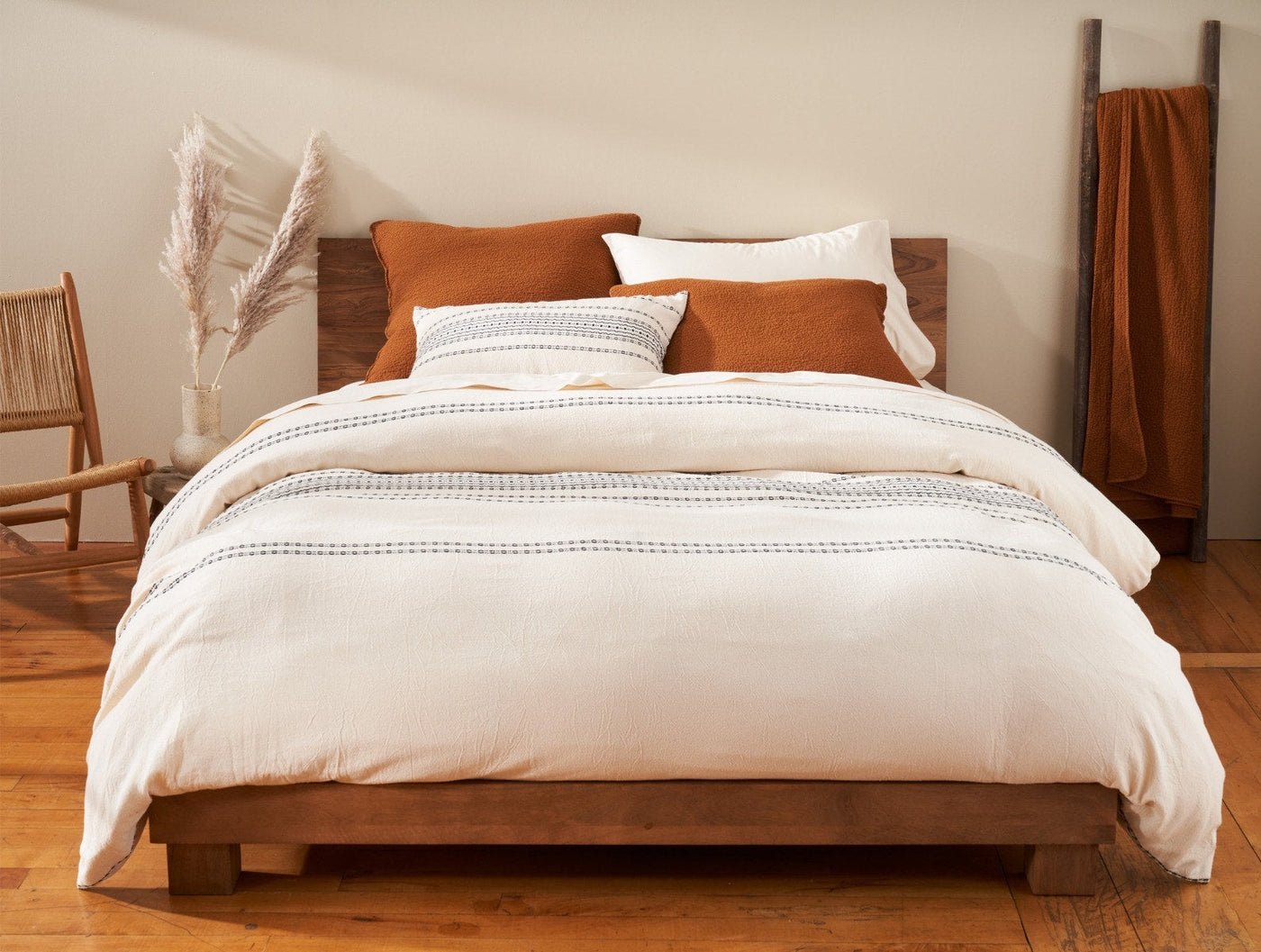 Coyuchi Rippled Stripe duvet cover in ivory with tonal stripe detail, styled on a wood bed.