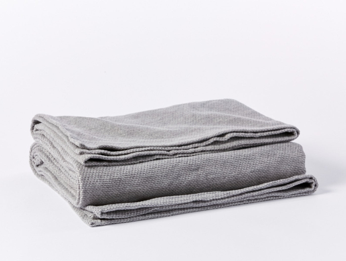 Coyuchi Sequoia blanket folded, showing silver grey waffle-knit texture detail.