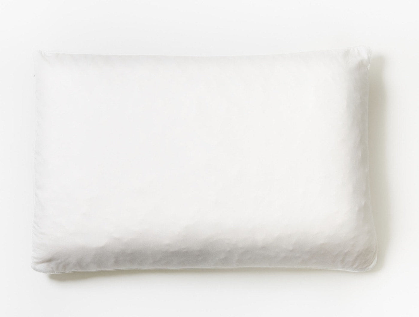 Overhead view of a white Coyuchi Latex pillow with softly rumpled linen casing.