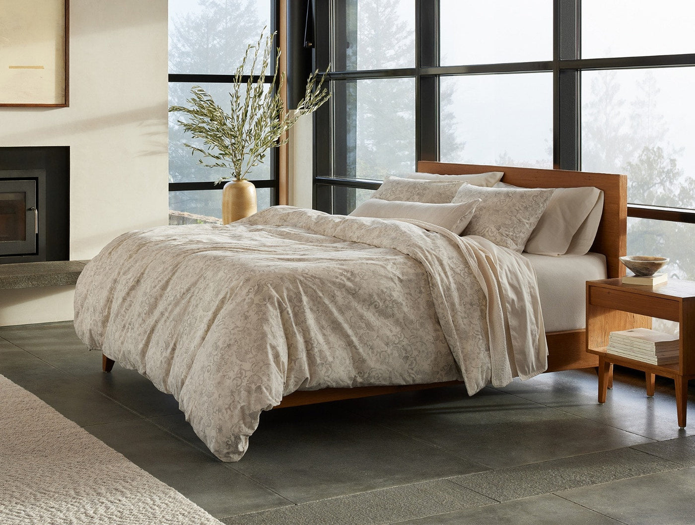 Coyuchi Solana Print duvet cover in taupe, styled on a wood-frame bed in a modern room.