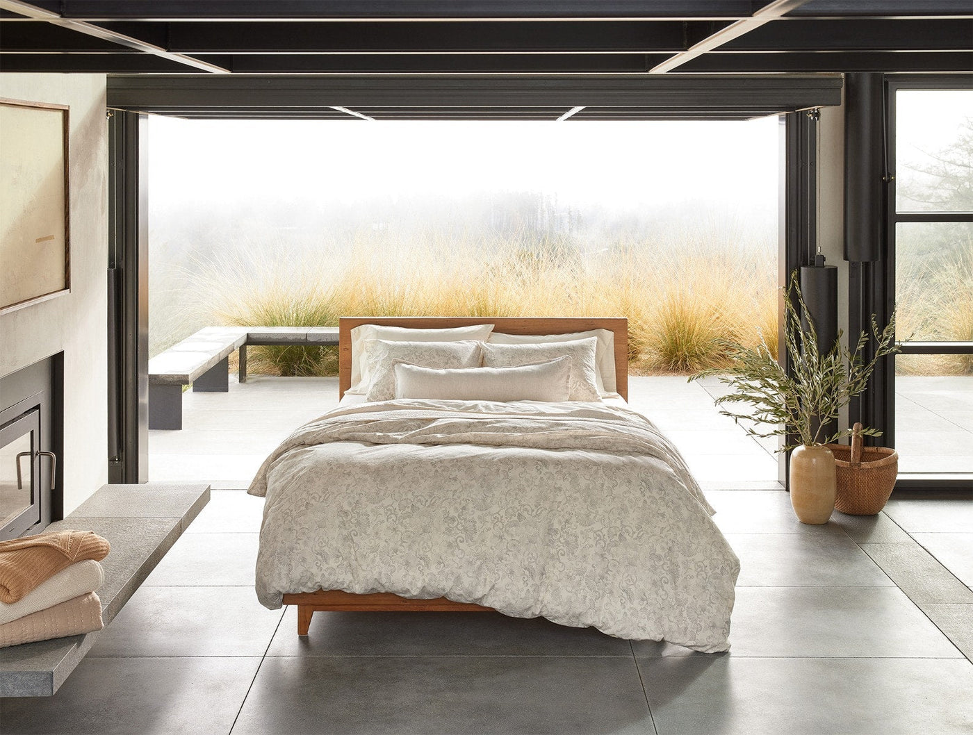 Coyuchi Solana Print duvet cover styled on bed in modern open room with natural landscape views.