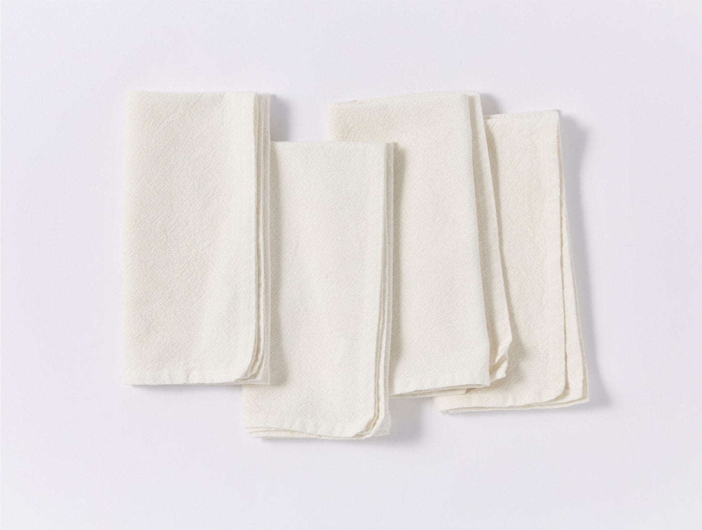 Coyuchi Sonoma Textured napkin set in ivory, twelve linen napkins fanned on white surface.