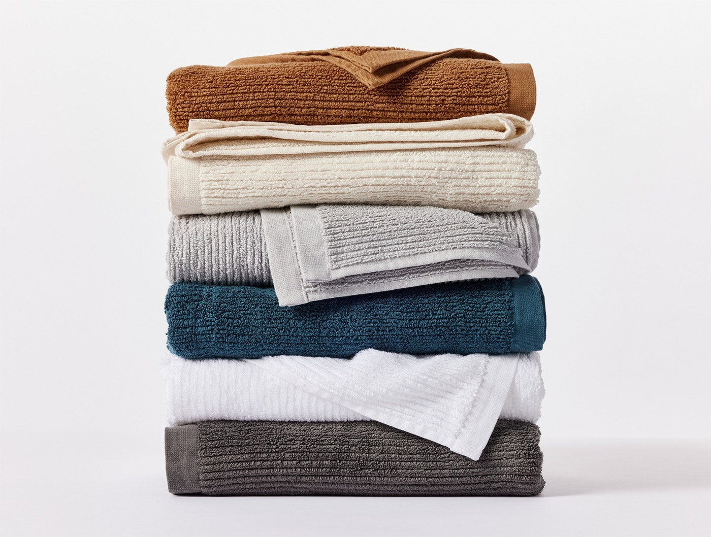 Stack of folded Coyuchi Temescal Ribbed bath towels in multiple colorways.