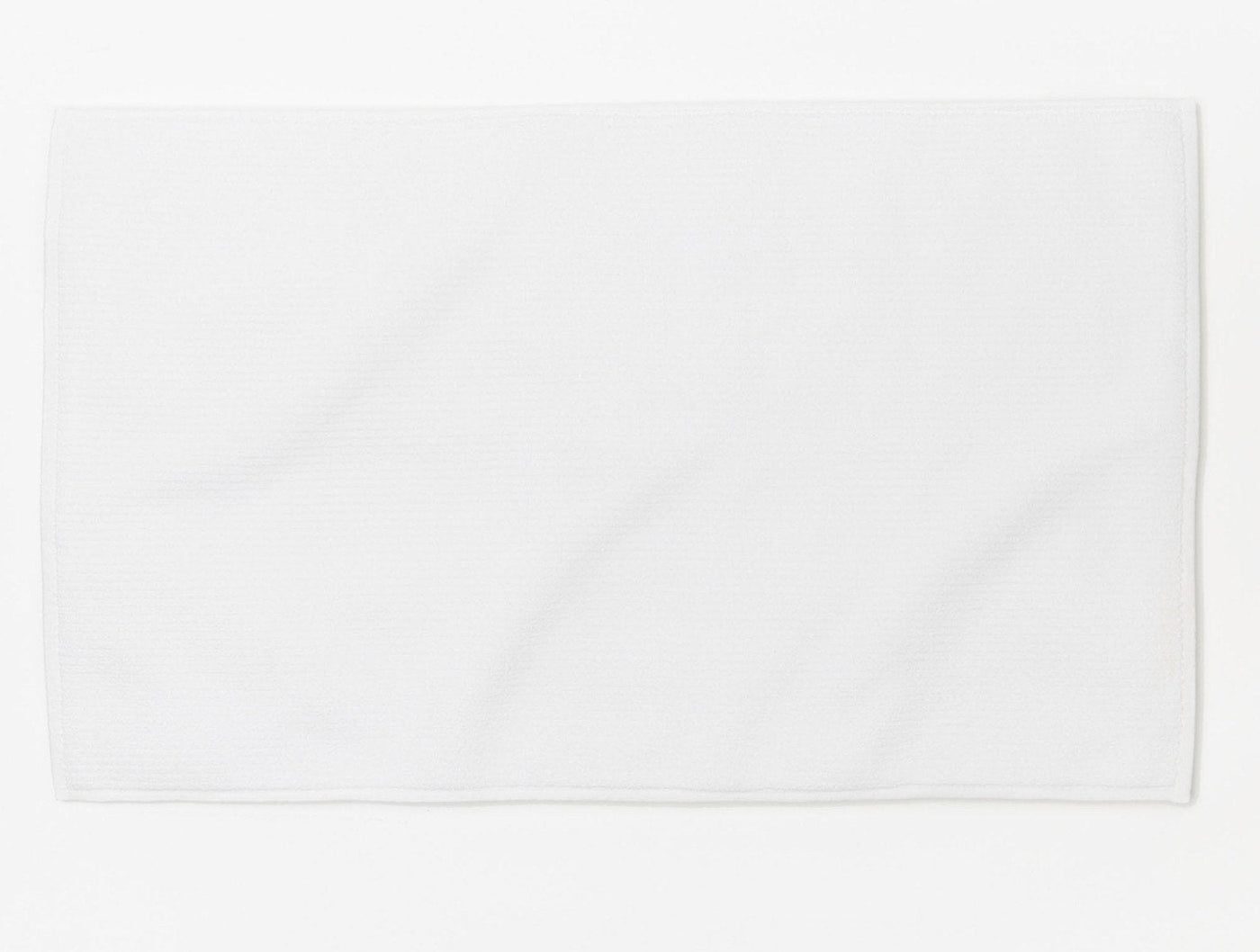 Coyuchi Temescal Ribbed bath rug in white, flat lay view on white background.