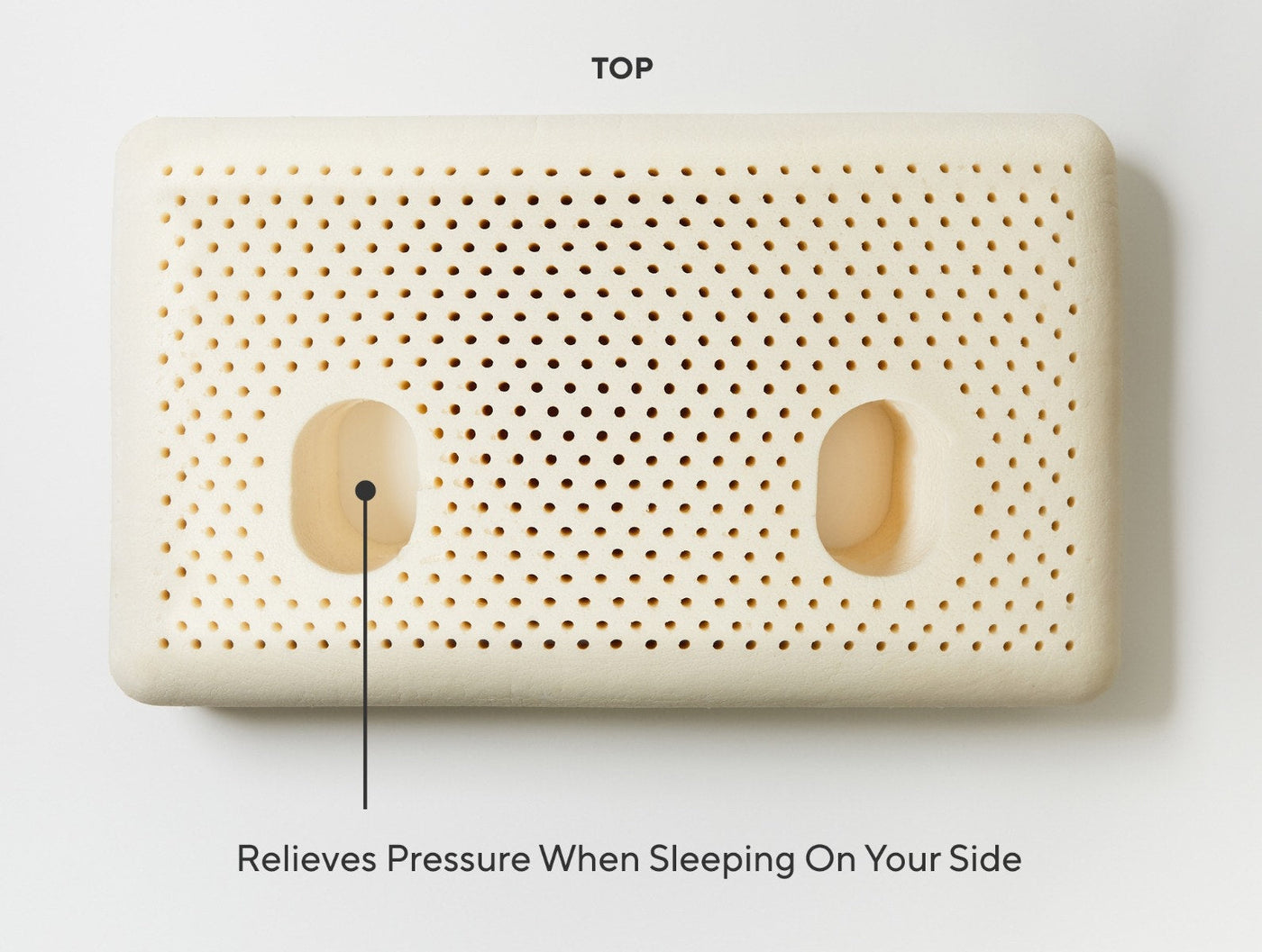 Top view of ivory latex pillow with ventilation holes and two oval cutouts for side sleeping.