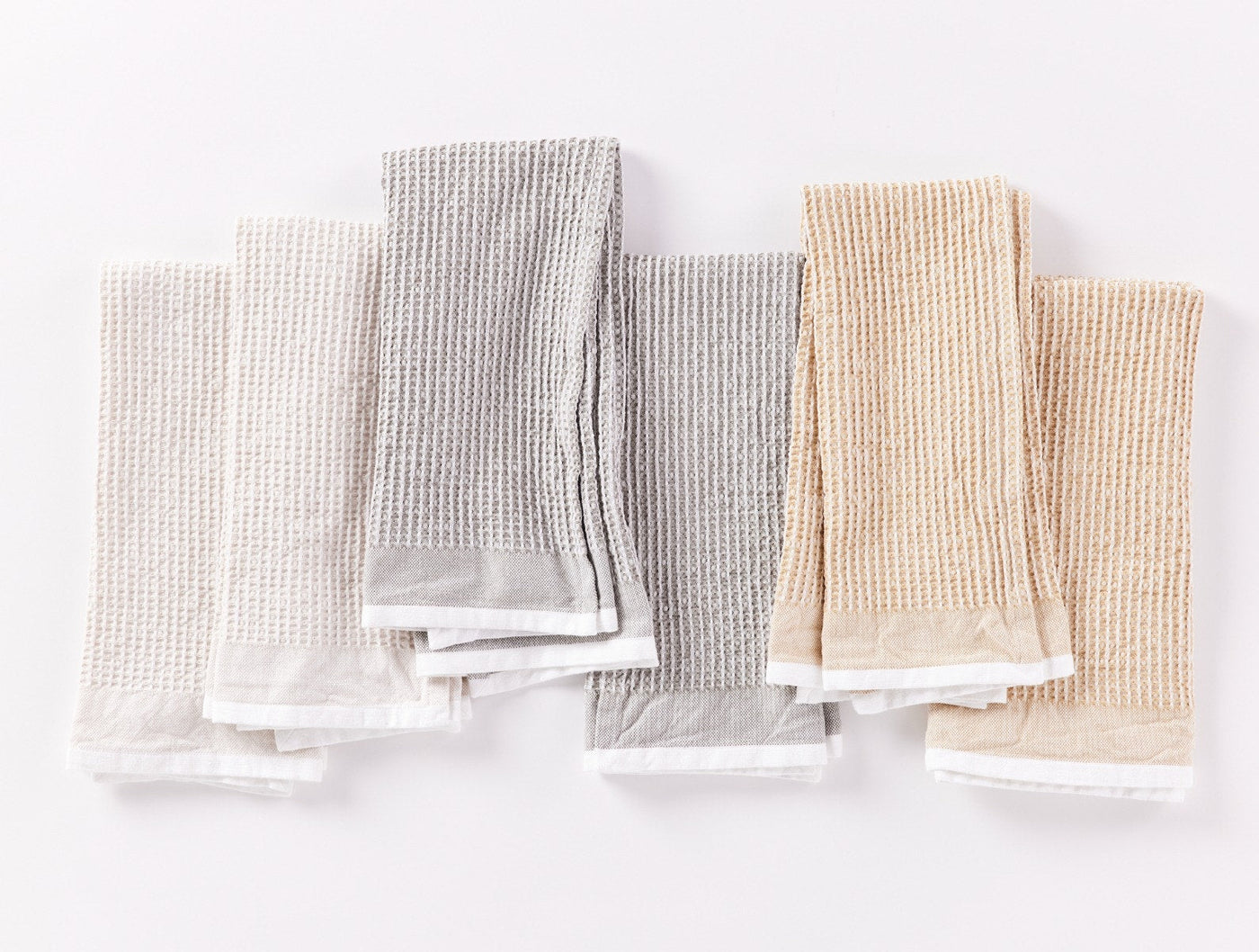 Coyuchi Waffle kitchen towels in grey and sand, flat lay showing set of six.
