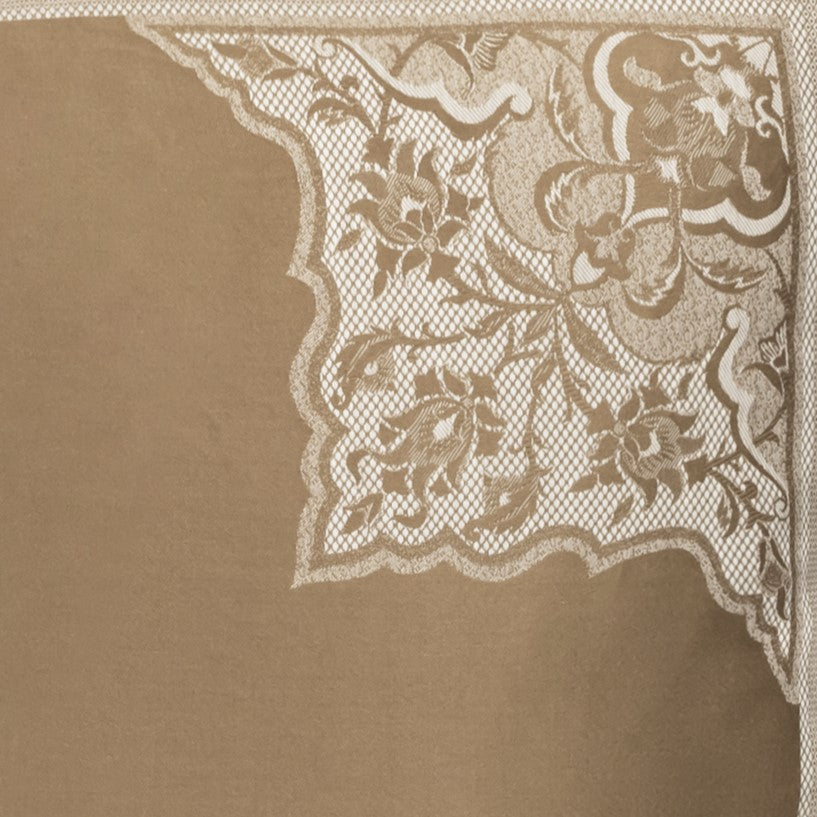 Corner detail of ivory floral lace trim on taupe linen duvet cover.