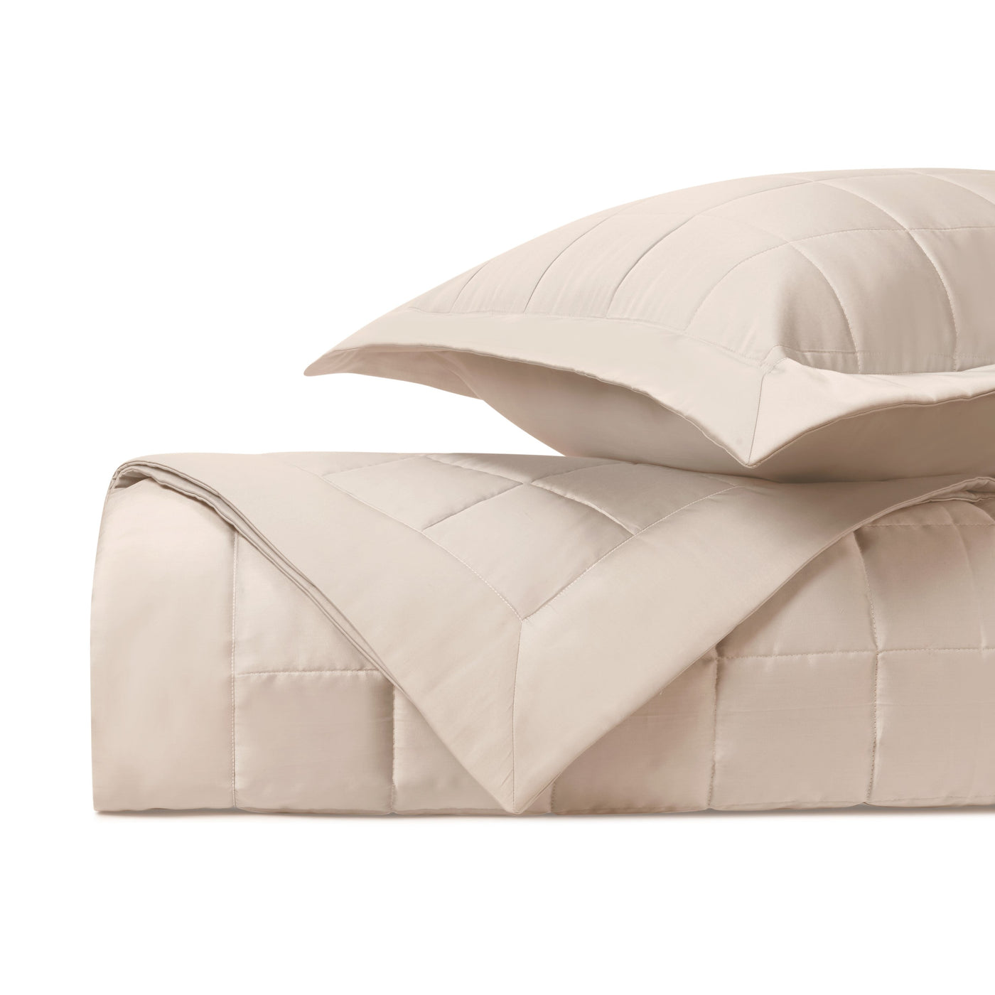 Plateau quilted comforter and sham in ivory, showing grid stitch pattern and folded presentation.