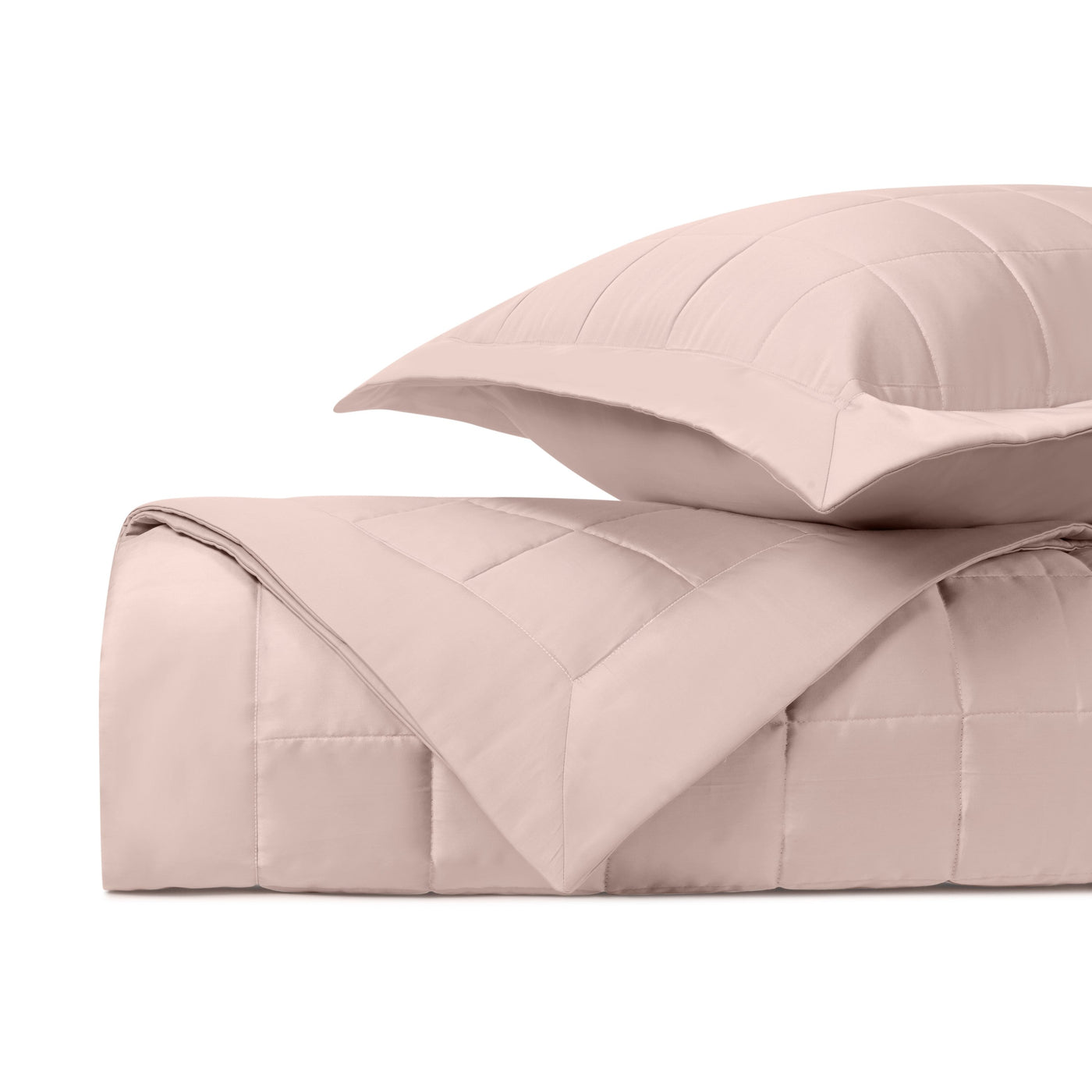 Close-up of Home Treasures Plateau quilted blush pink comforter and sham set, folded.