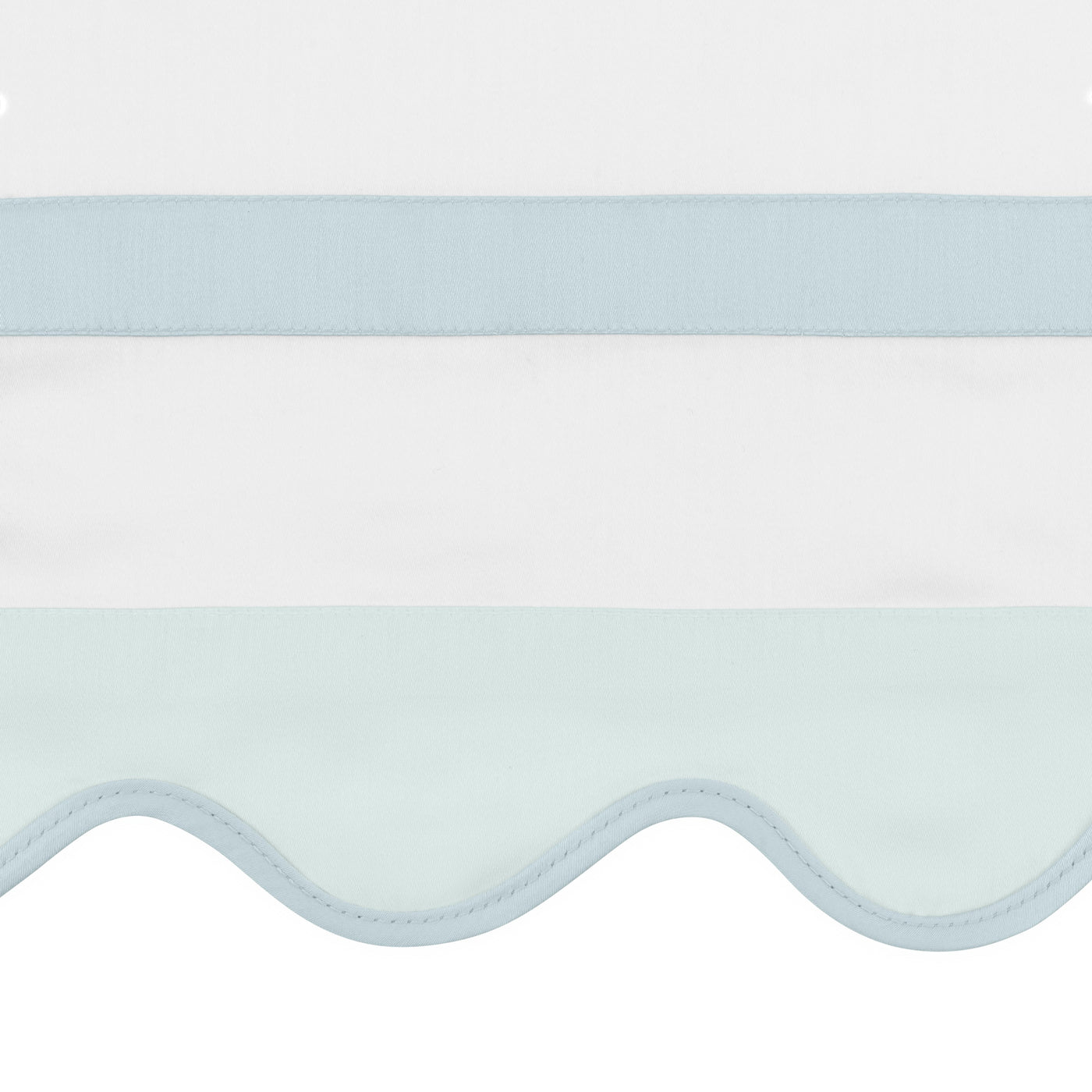 Close-up of scalloped hem edge with powder blue ribbon trim on white cotton sham.
