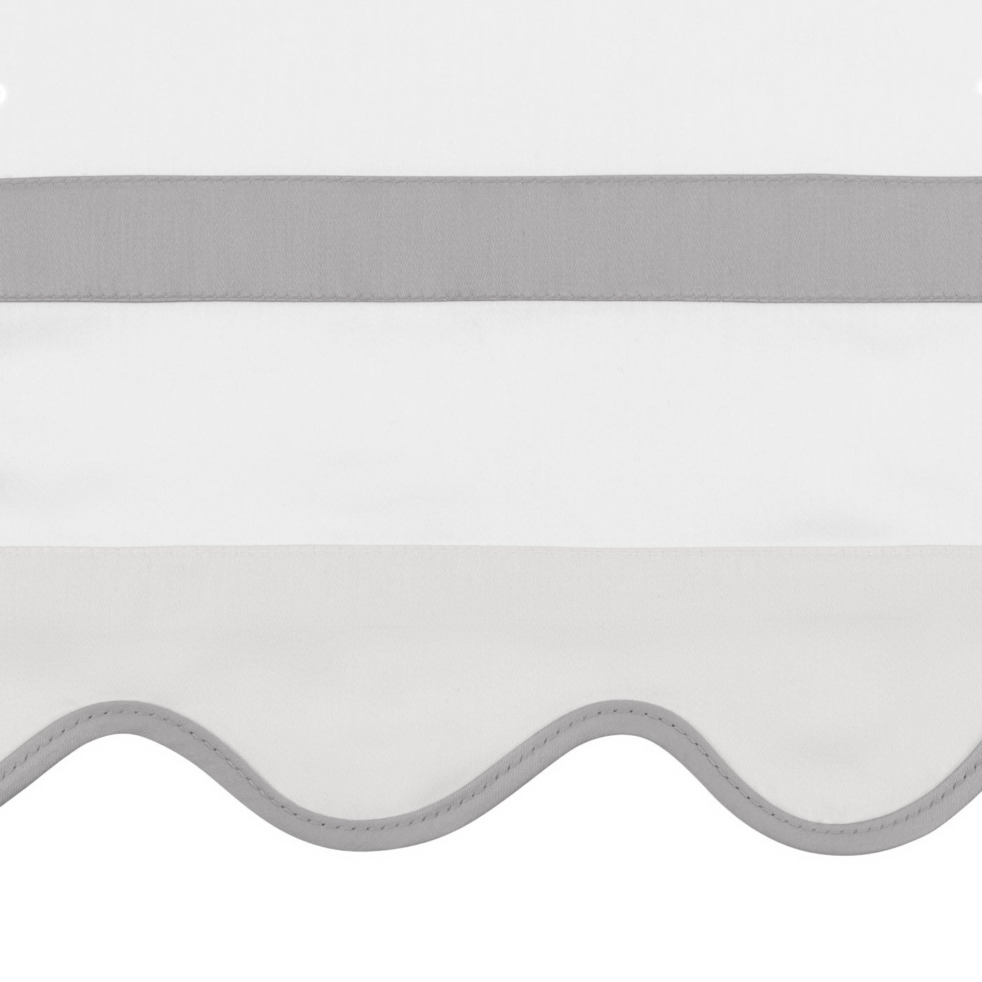 Close-up of scalloped edge with silver-grey trim and woven border band on white linen.