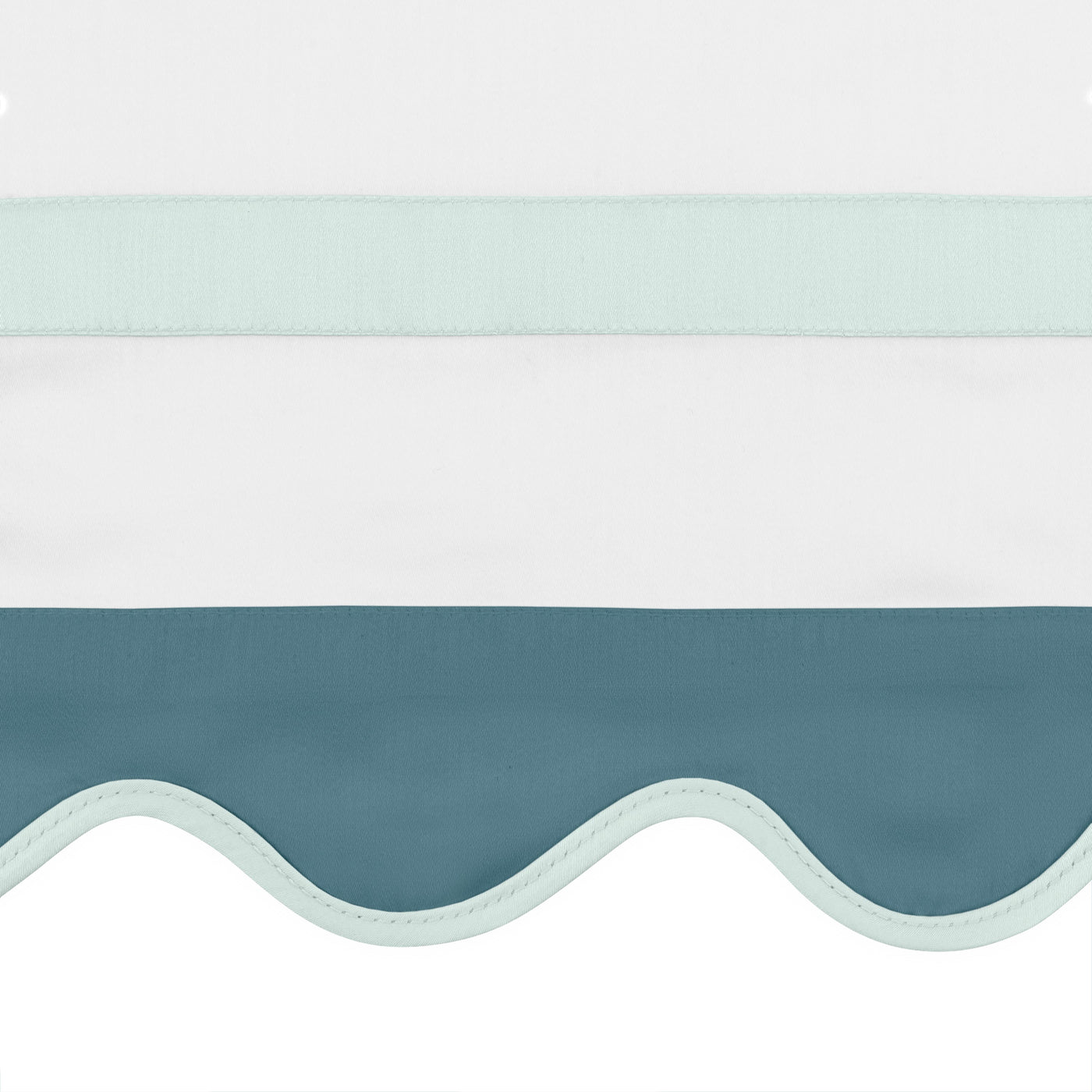 Close-up of scalloped slate blue edge with mint trim on white linen pillow sham.