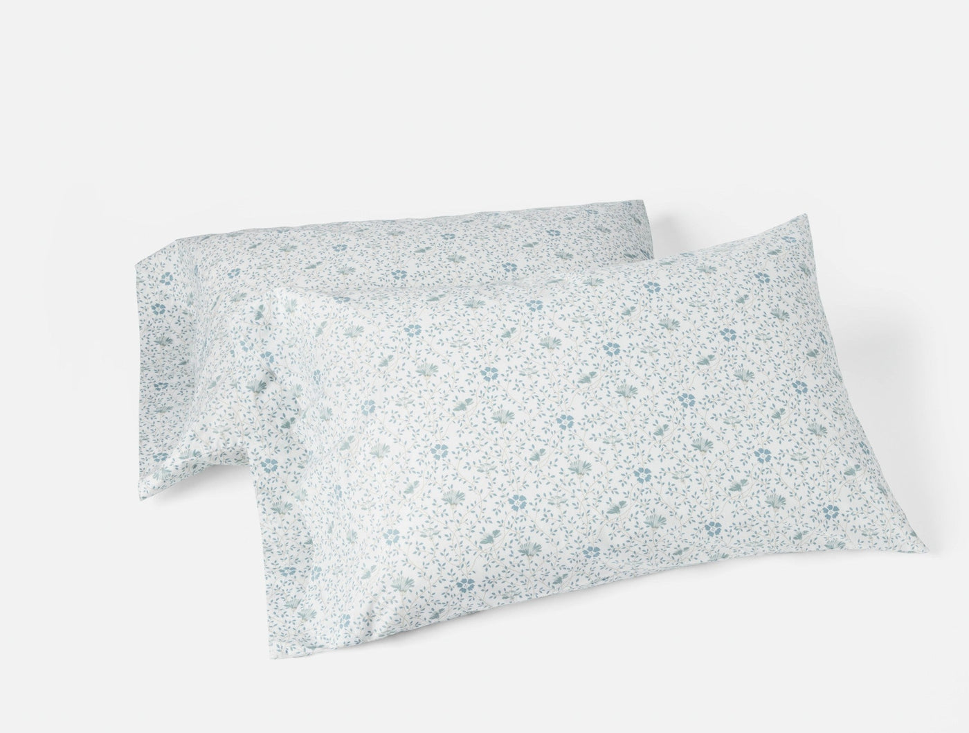 Two white percale pillowcases with delicate blue floral print, stacked at an angle.