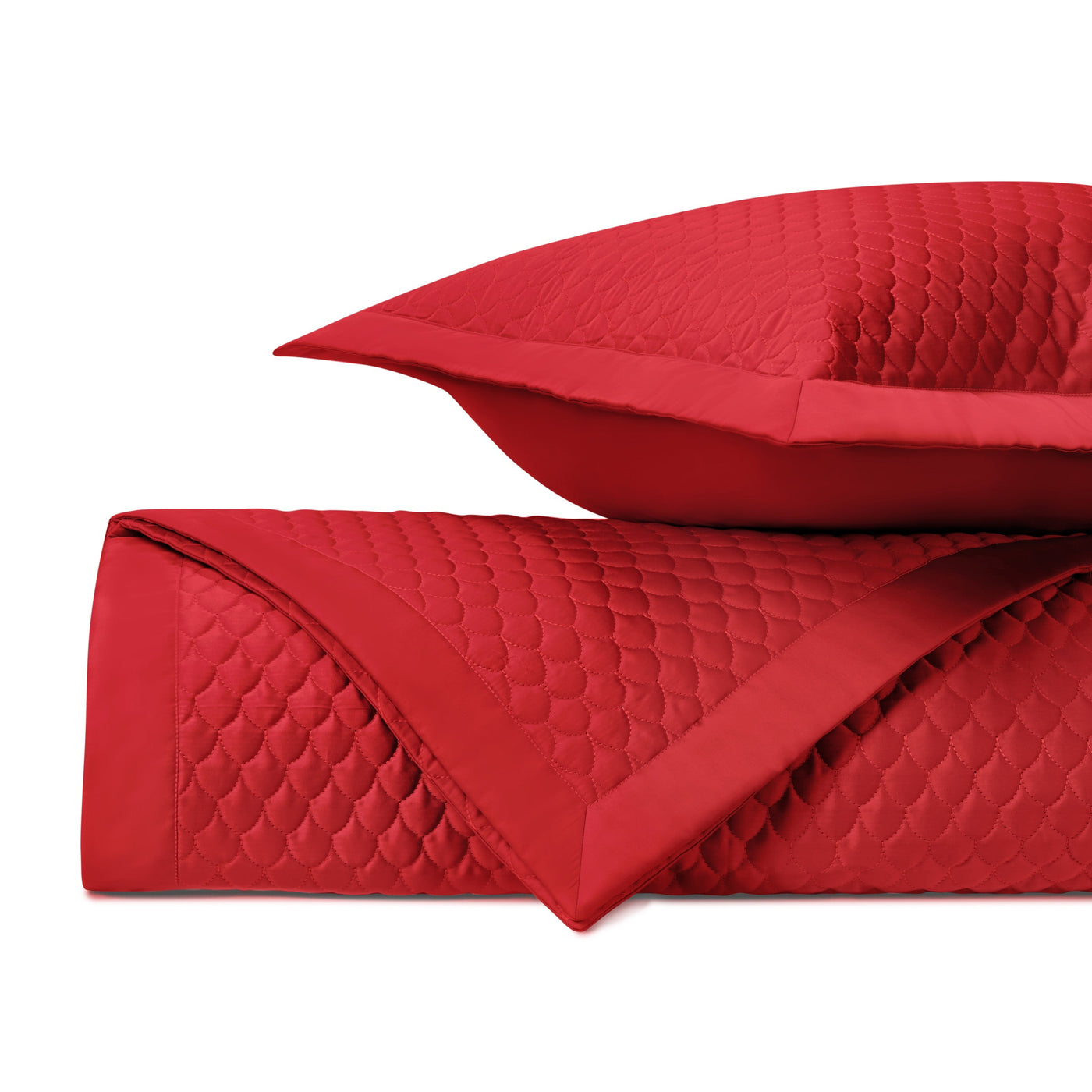 Close-up of crimson quilted fabric with scalloped raindrop stitching pattern and satin trim.