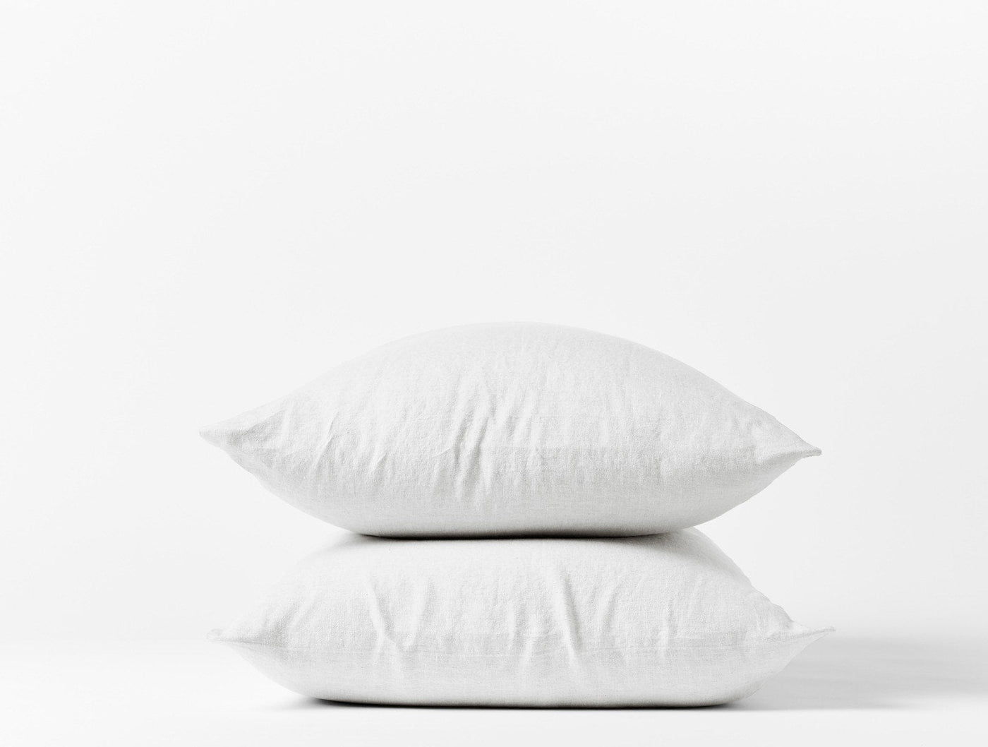 Coyuchi Relaxed Linen pillowcase pair in white, two pillows stacked on white background.