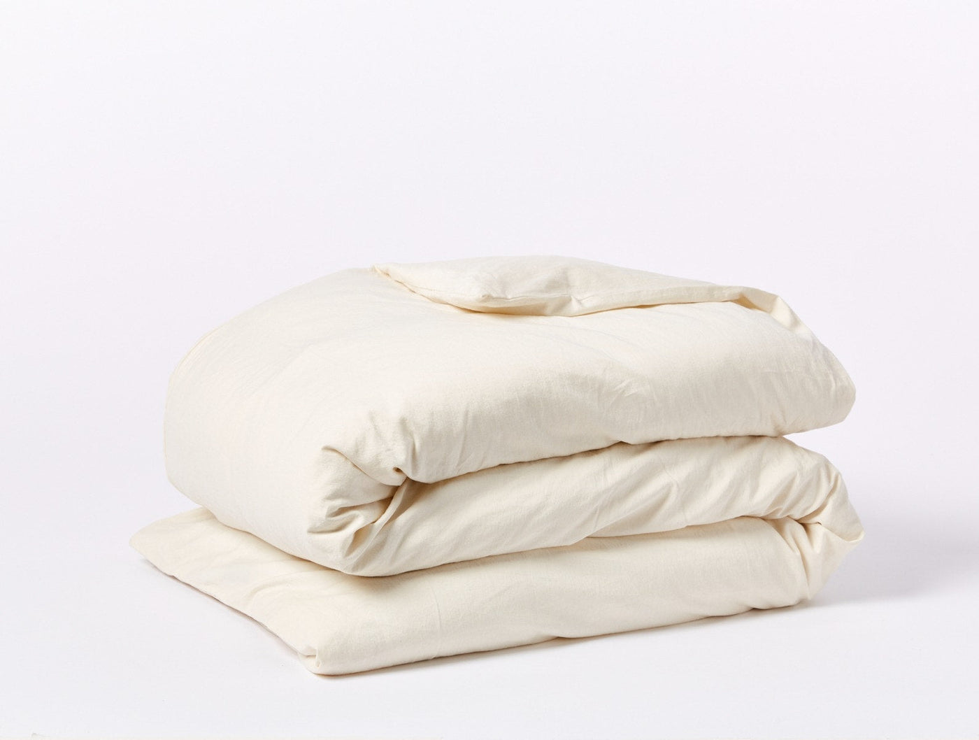 Coyuchi Cloud Soft Sateen duvet cover folded, ivory sateen finish, side angle view.