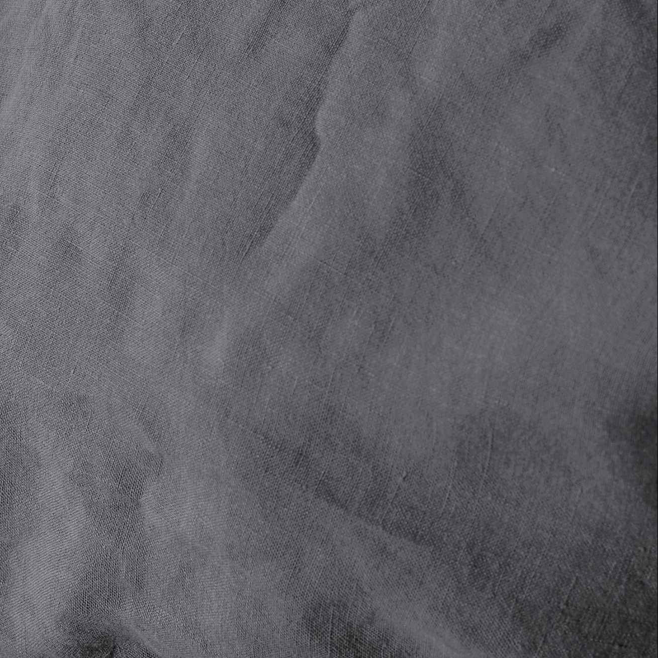 Close-up of charcoal linen fabric showing natural crinkled texture.