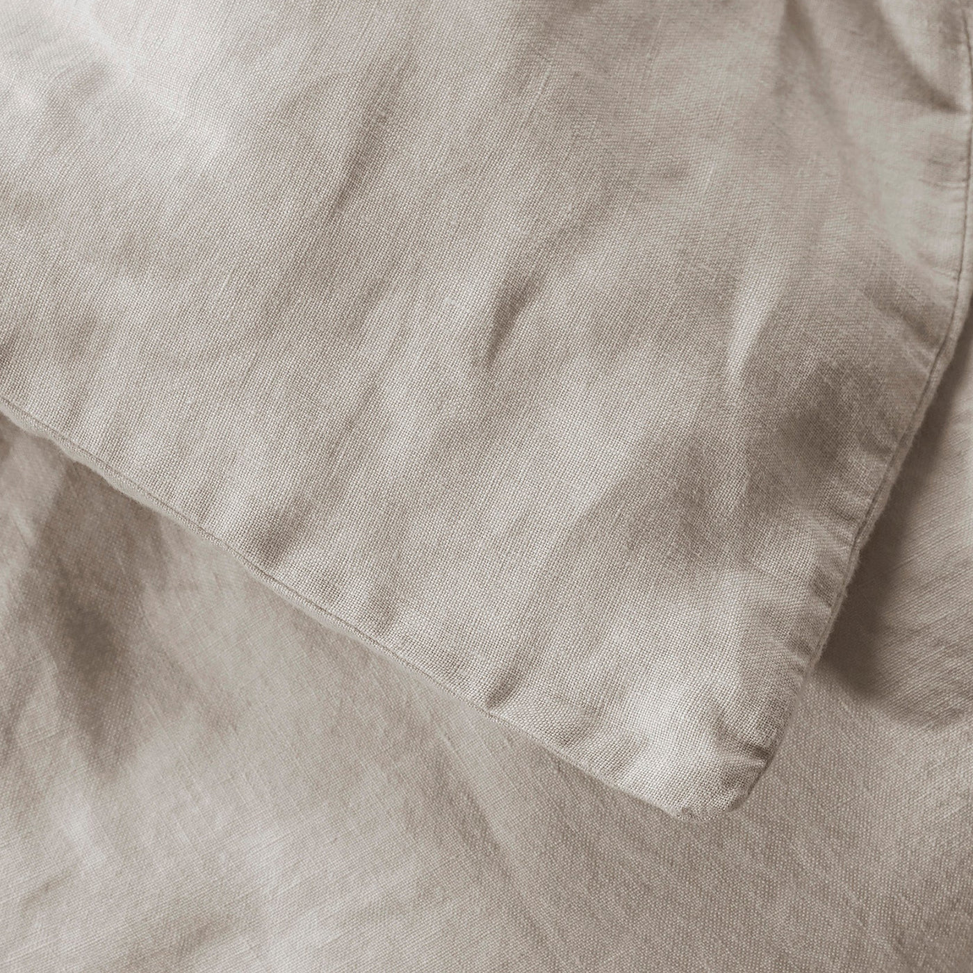 Close-up of Society Limonta Rem duvet cover hem detail in warm taupe linen.