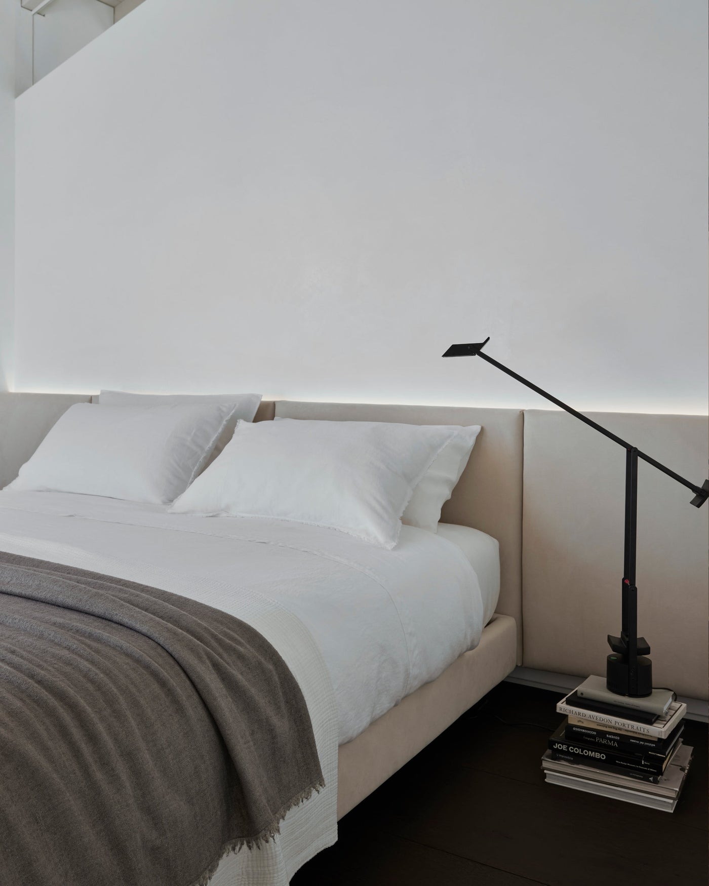 Close-up of Society Limonta Rem flat sheet in white on a made bed with grey throw.