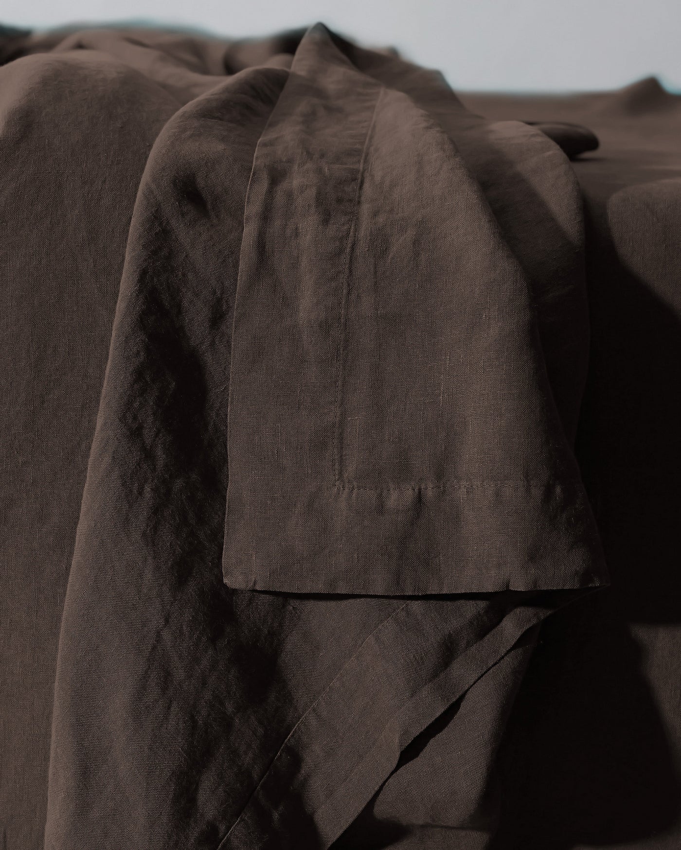 Close-up of Society Limonta Rem flat sheet hem detail in deep espresso linen.