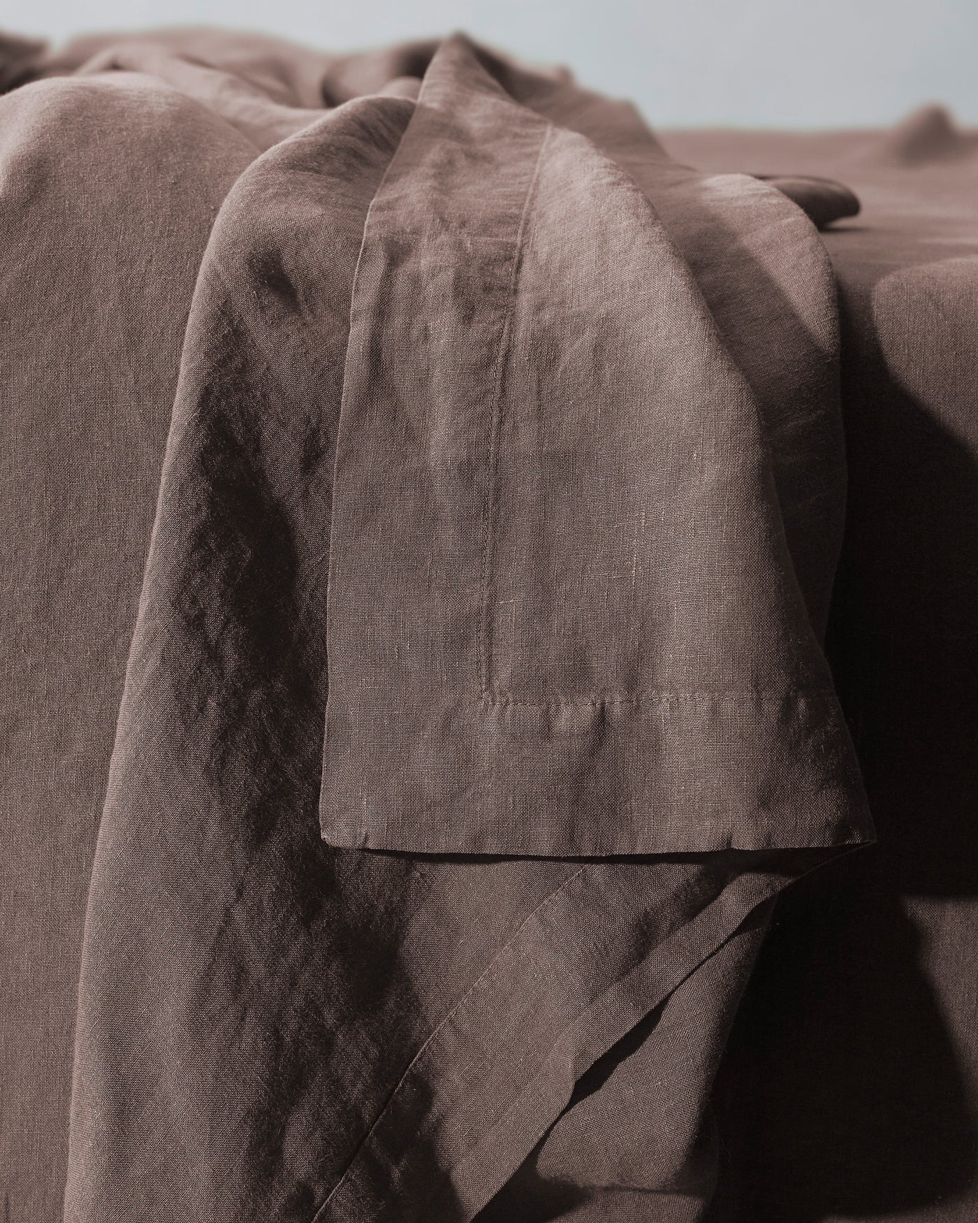 Close-up of Society Limonta Rem flat sheet hem detail in warm cocoa linen.