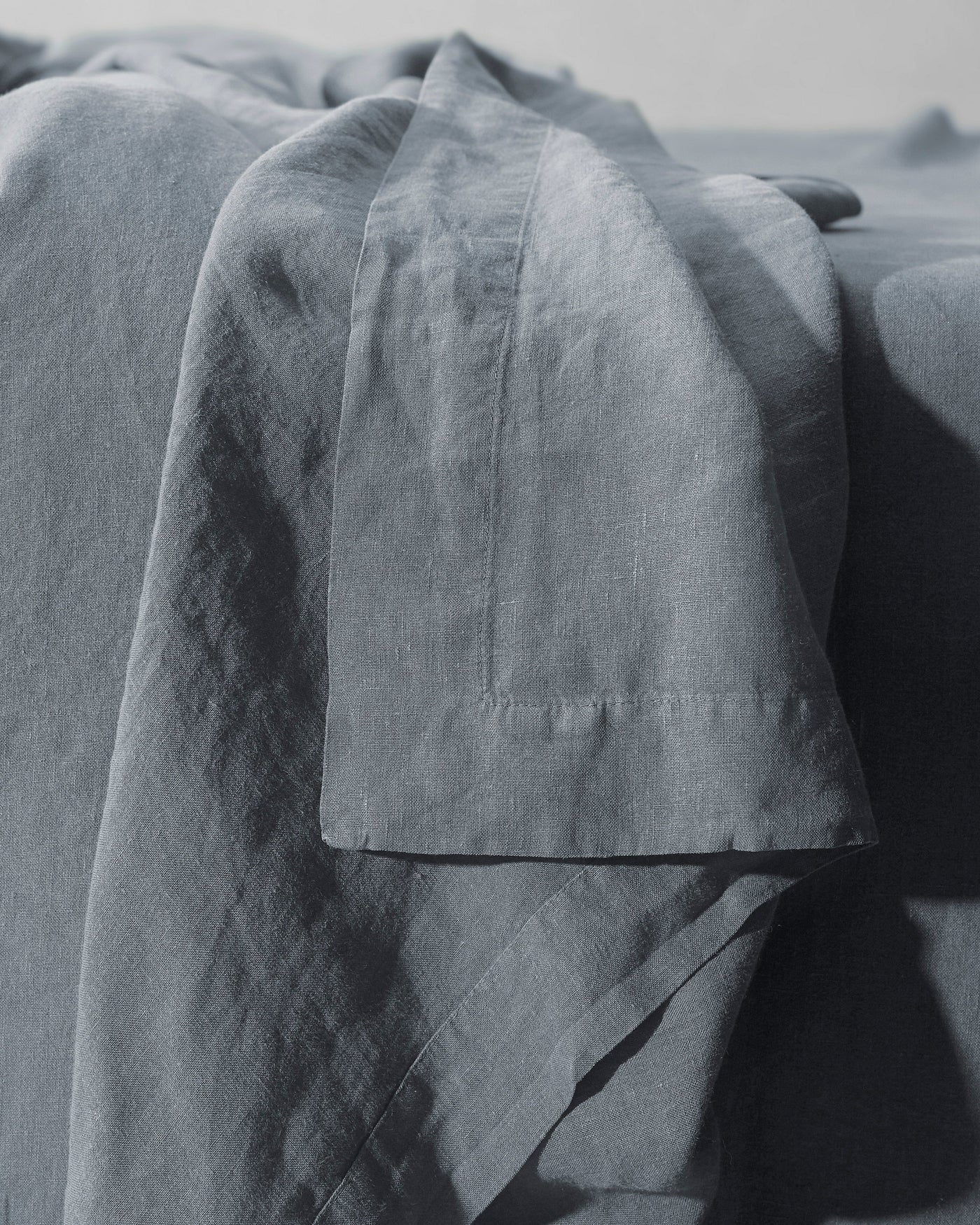 Close-up of Society Limonta Rem flat sheet hem detail in slate linen.