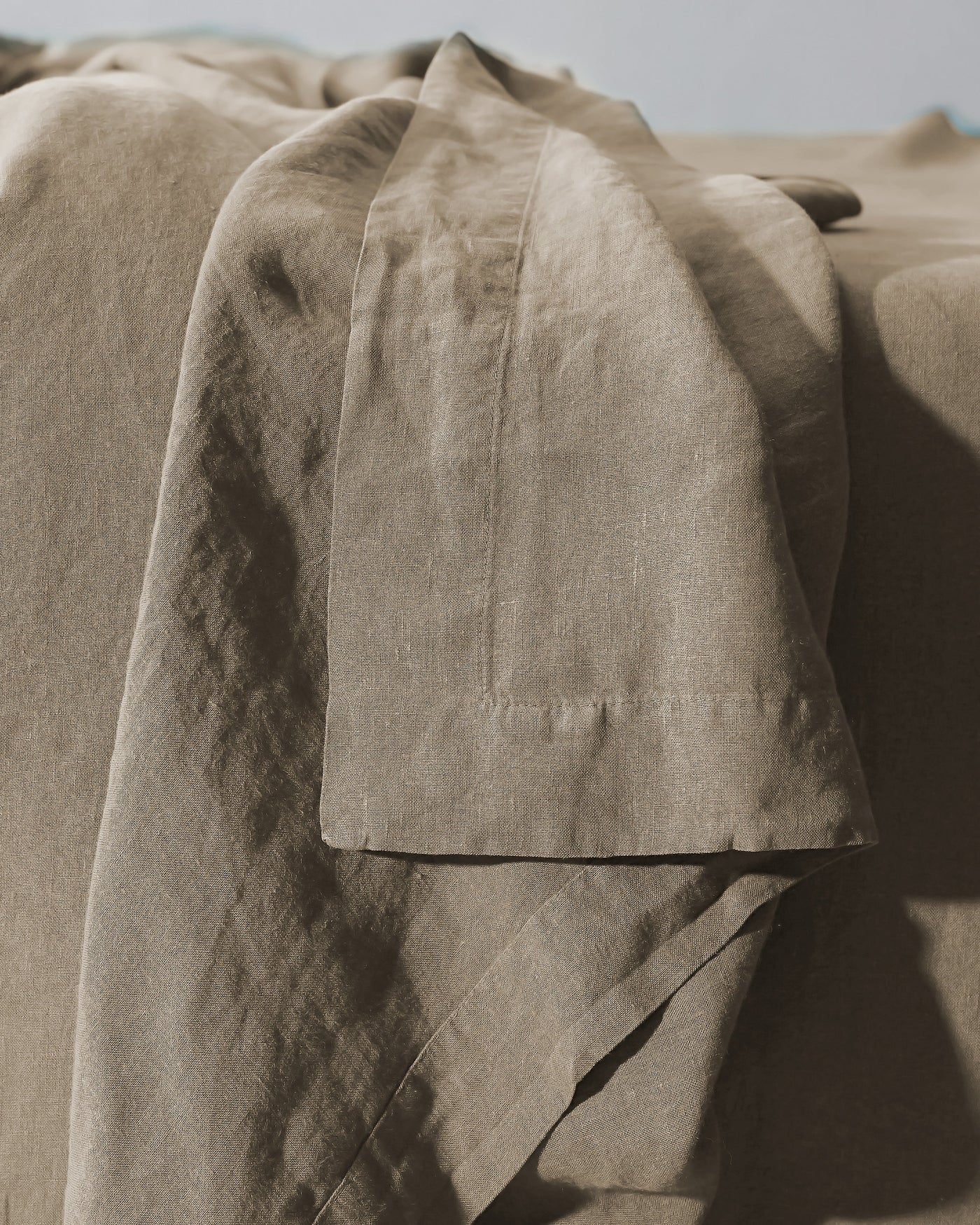 Close-up of Society Limonta Rem flat sheet hem detail in warm taupe linen.