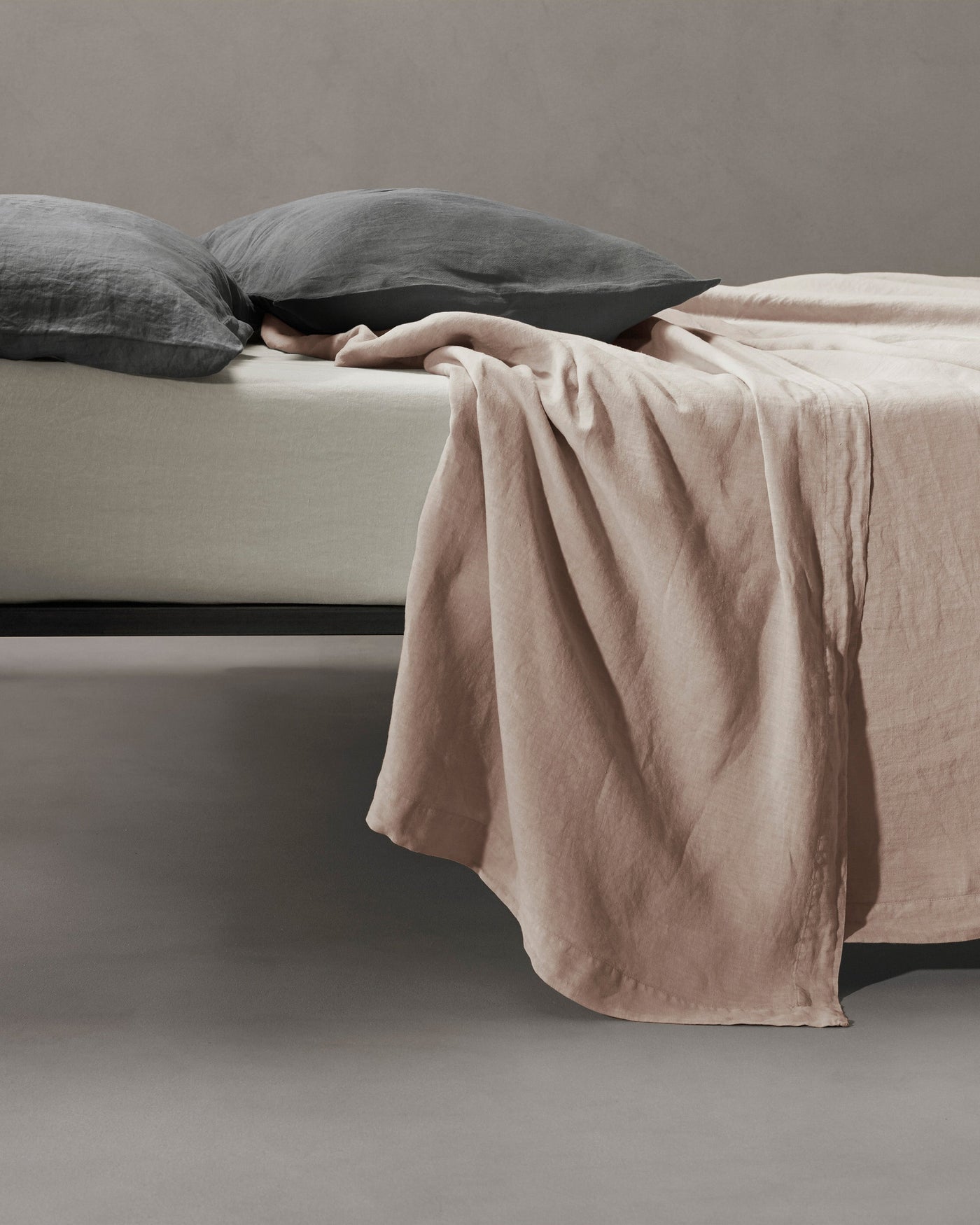 Society Limonta Rem flat sheet in blush, draped loosely over bed edge.