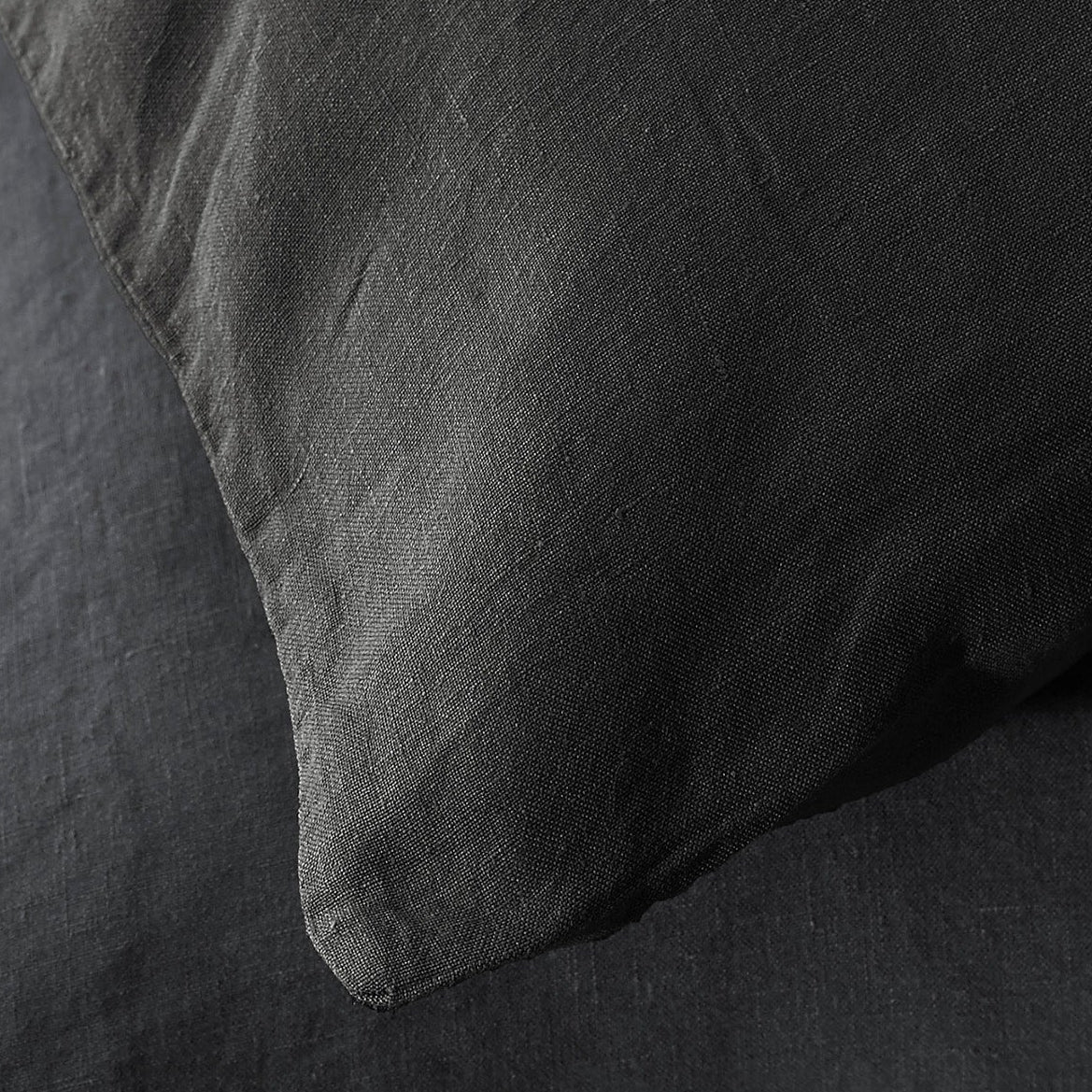 Close-up of Society Limonta Rem pillowcase corner in charcoal washed linen.