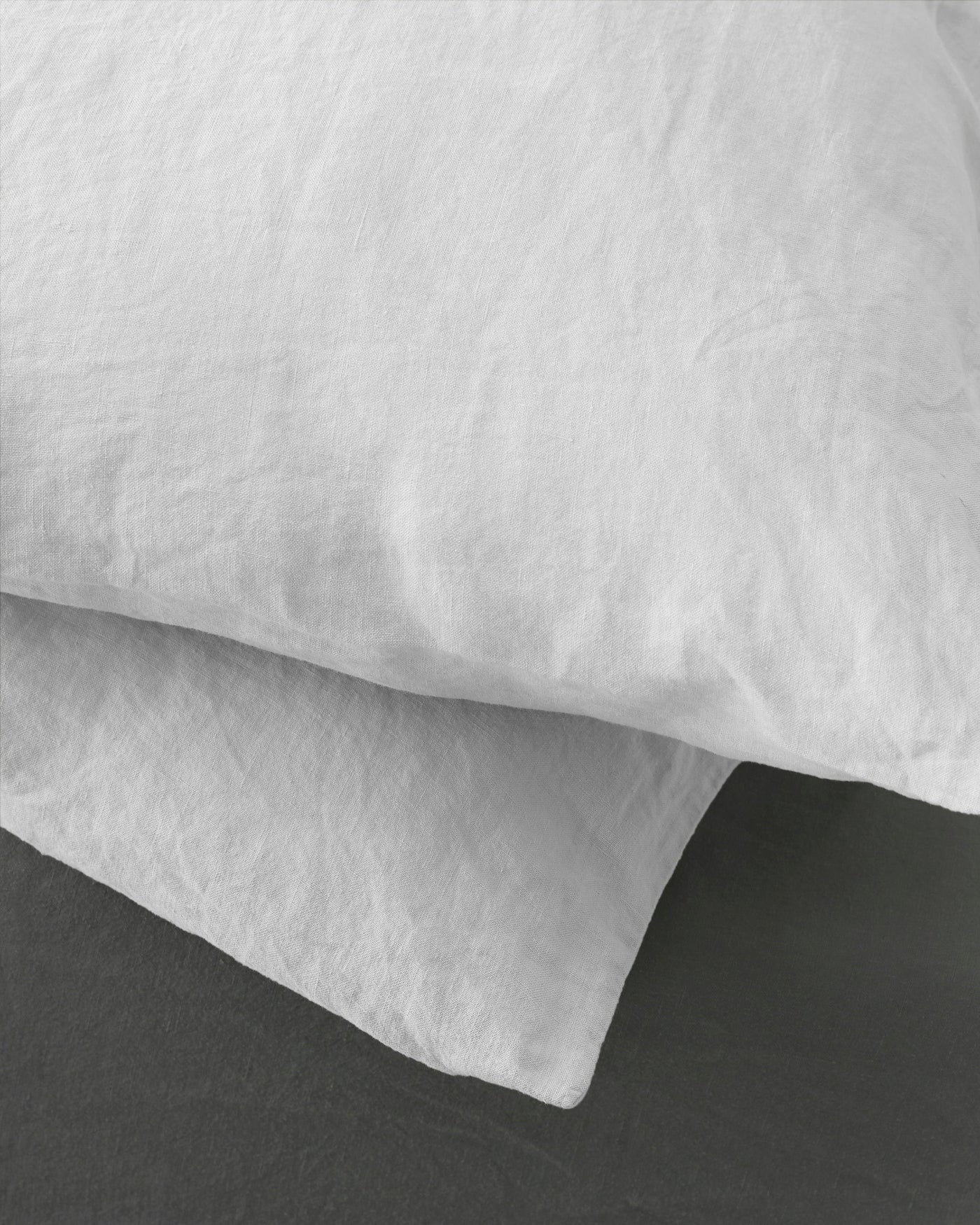 Close-up of white washed linen pillowcase showing natural texture and relaxed drape.