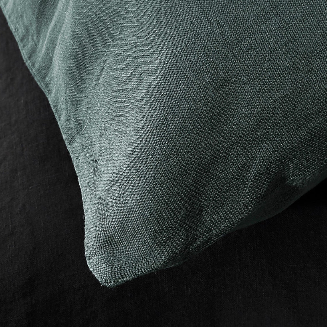 Close-up of Society Limonta Rem pillowcase corner in sage, showing washed linen texture.