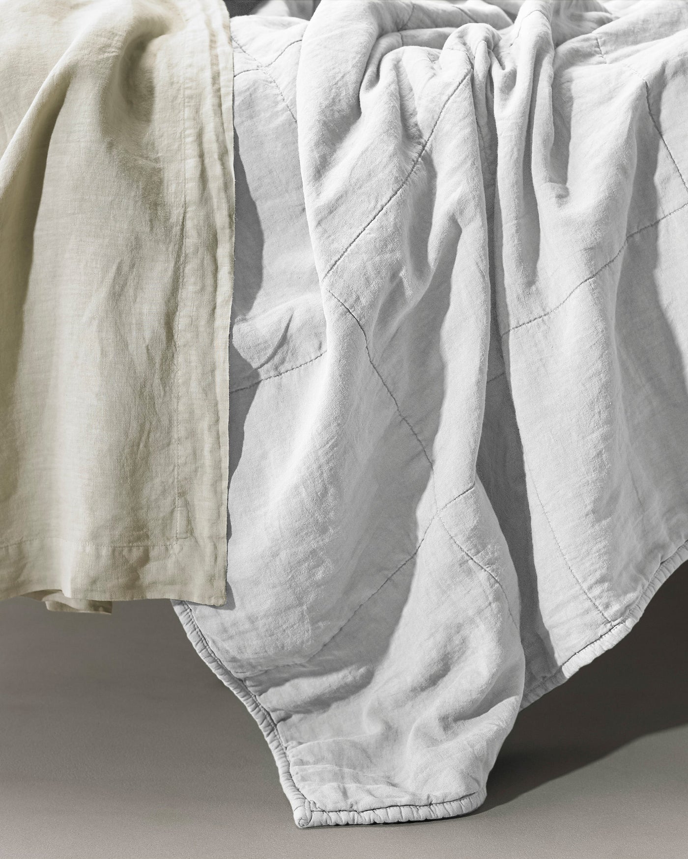Close-up of Society Limonta Rem quilt in white linen with diamond quilting detail.